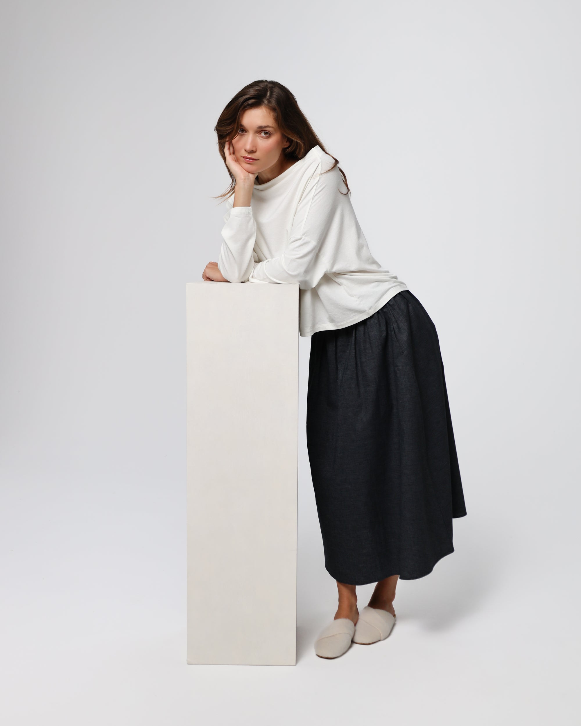 Model styling Off The Shoulder Top (white) with tailored trousers for an elevated minimalist look.