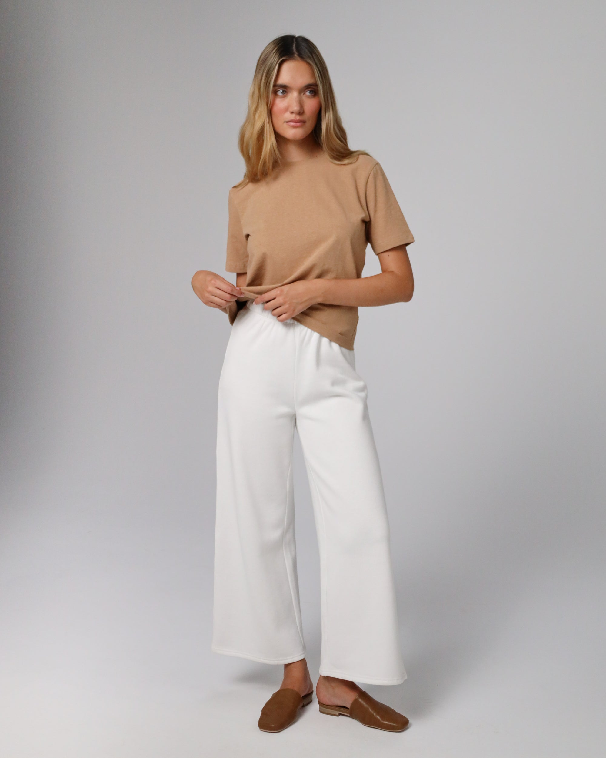 Model styling Short Sleeve Tee (fawn) with tailored trousers for minimalist polish.