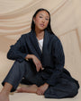 Model wearing Juana Hemp High Rise Trousers in natural hemp and organic cotton blend, styled for a relaxed yet tailored look.