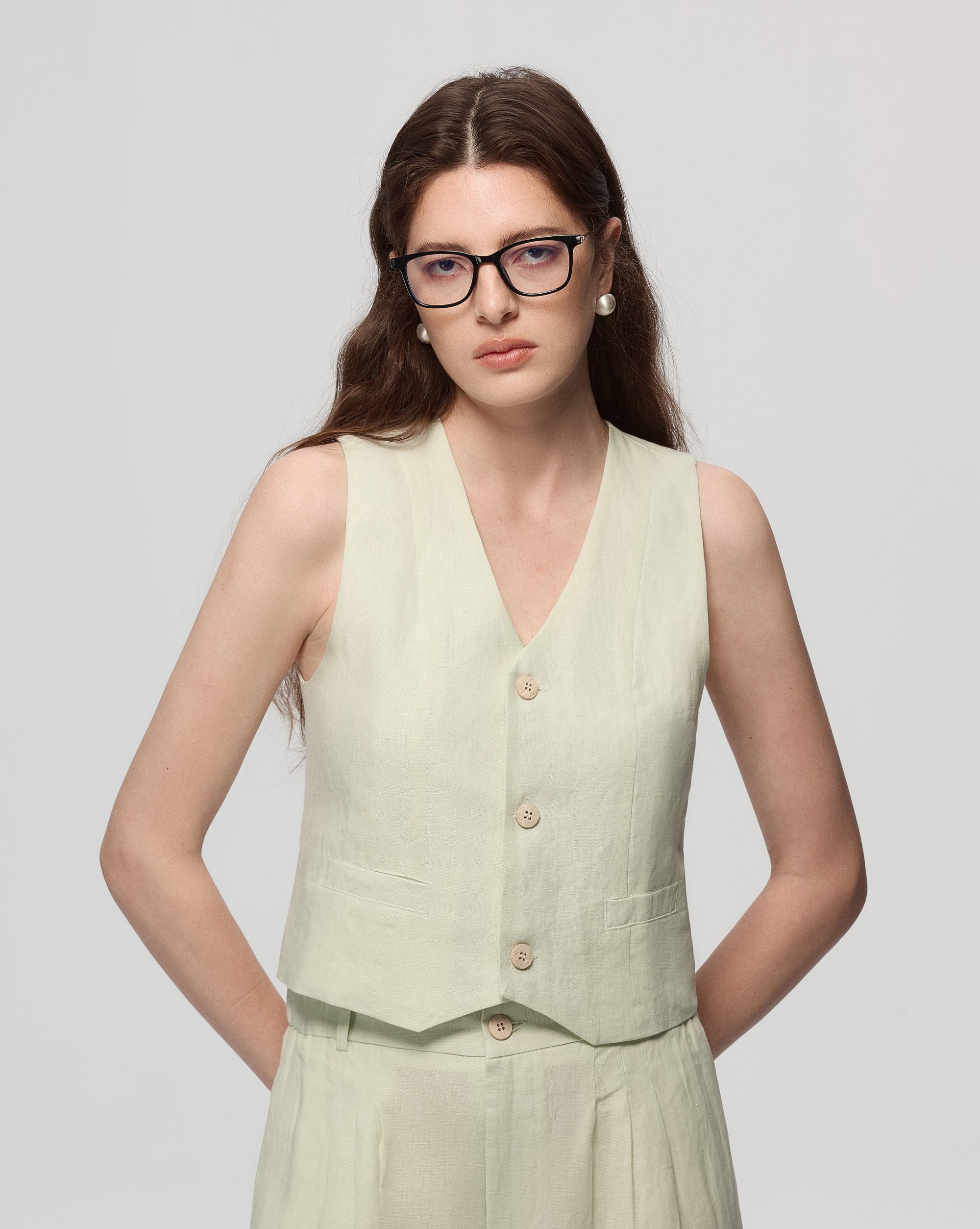 Model wearing Juana Hemp Tailored Vest in light mint (hemp), showing tailored fit and clean V-neck front.