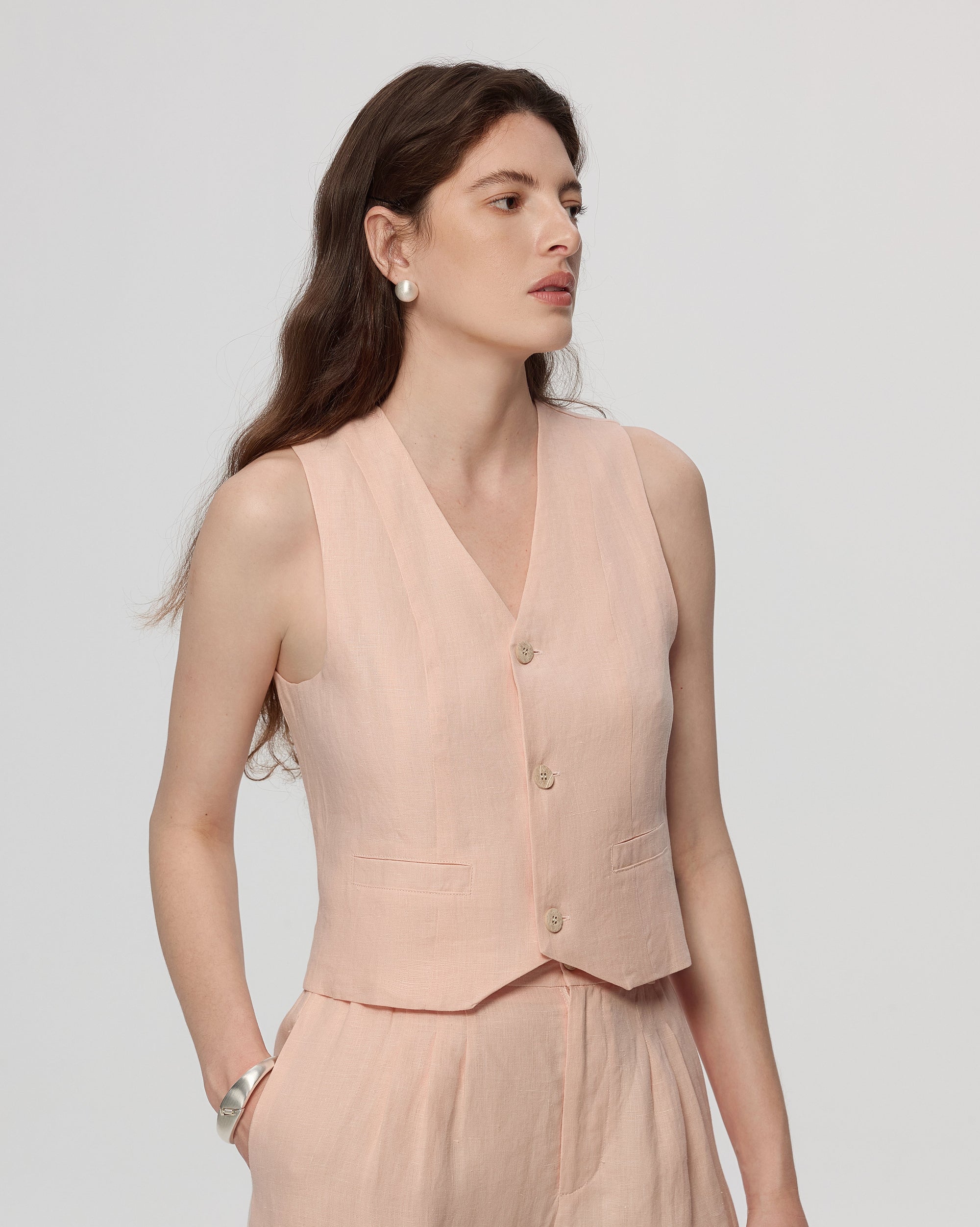 Model wearing Juana Hemp Tailored Vest in light peach (hemp), styled for polished layering with a minimal silhouette.