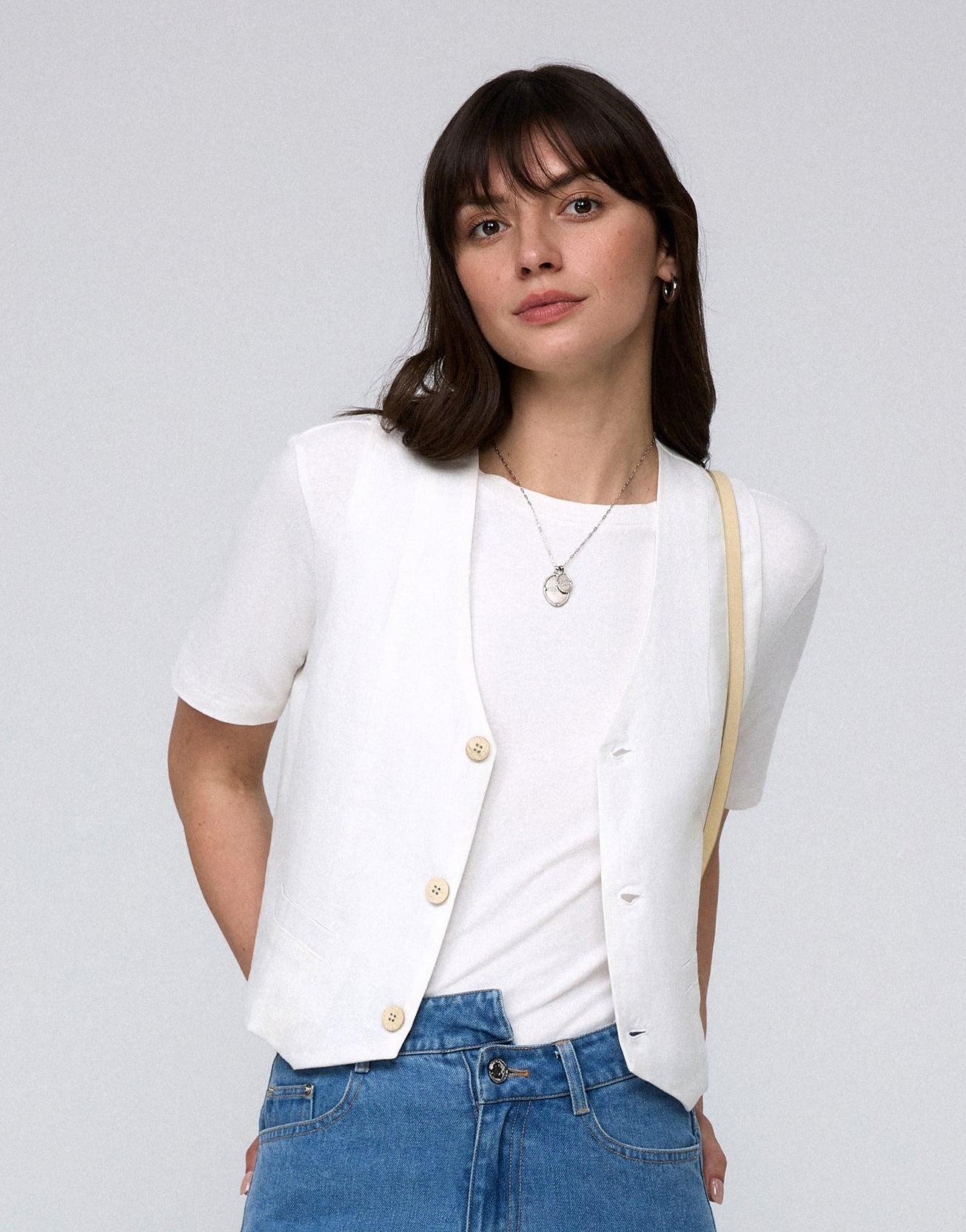 Model wearing Juana Hemp Tailored Vest in white (hemp), showing tailored fit and clean V-neck front.