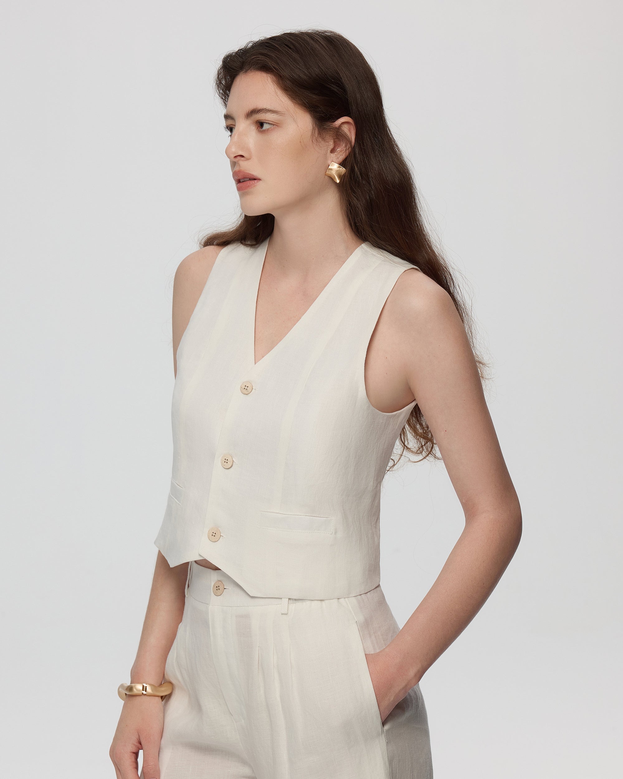 Model wearing Juana Hemp Tailored Vest in white (hemp), showing tailored fit and clean V-neck front.