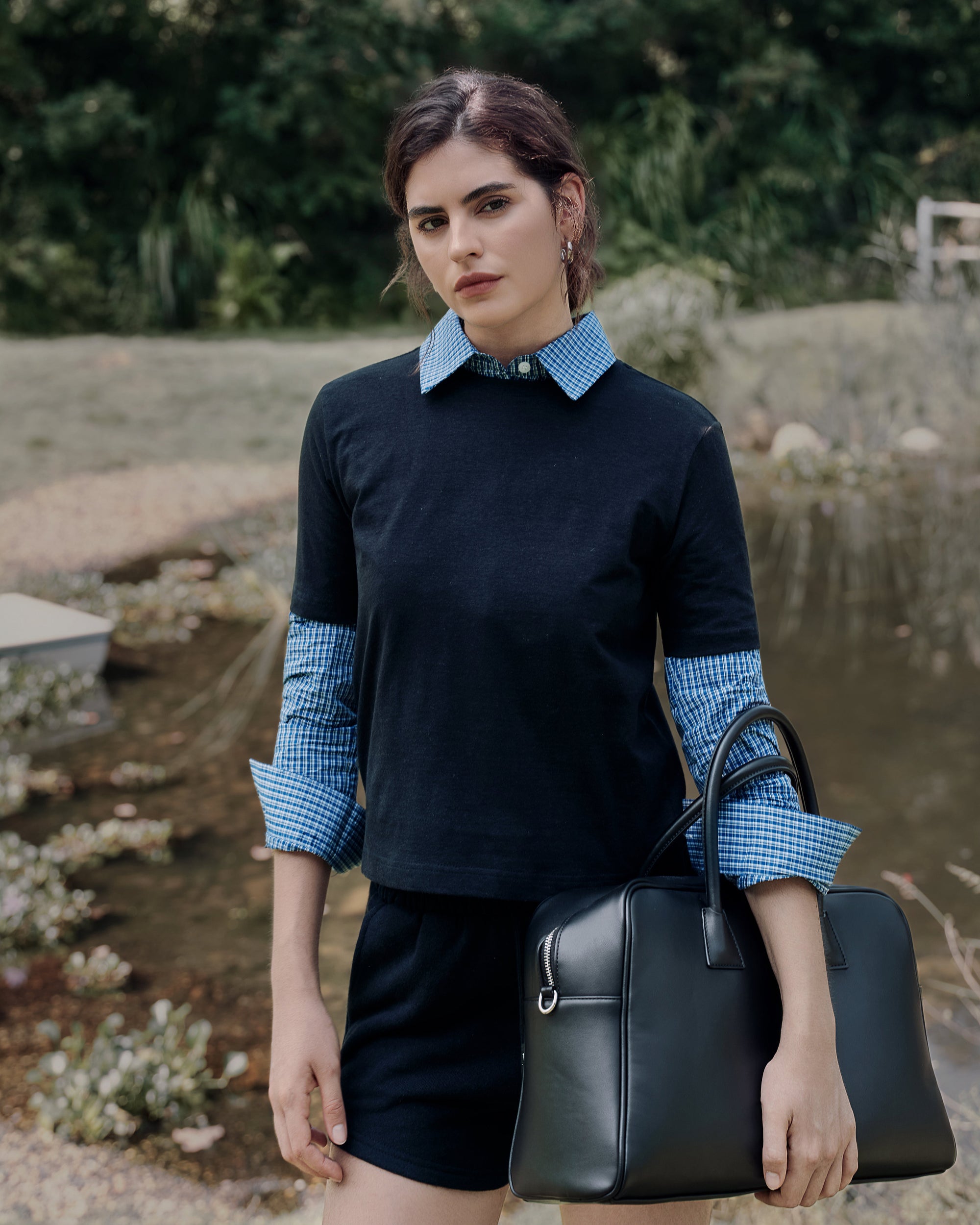 Motion shot by the lake capturing white tee over blue shirt with gray fleece shorts; airy movement in natural fibers.