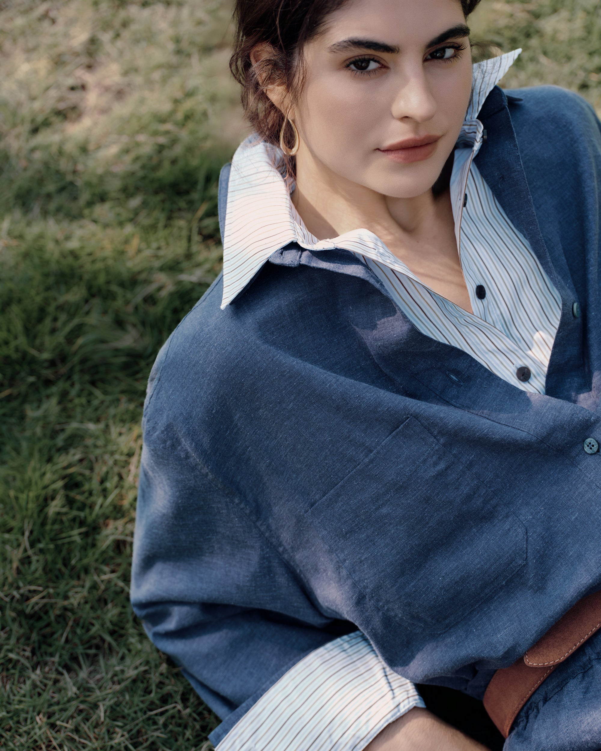 Greenhouse detail of corozo buttons on Lyricist Shirt indigo blue, layered over white shirt, with Lyricist Pull-on Pants indigo blue elastic waistband.