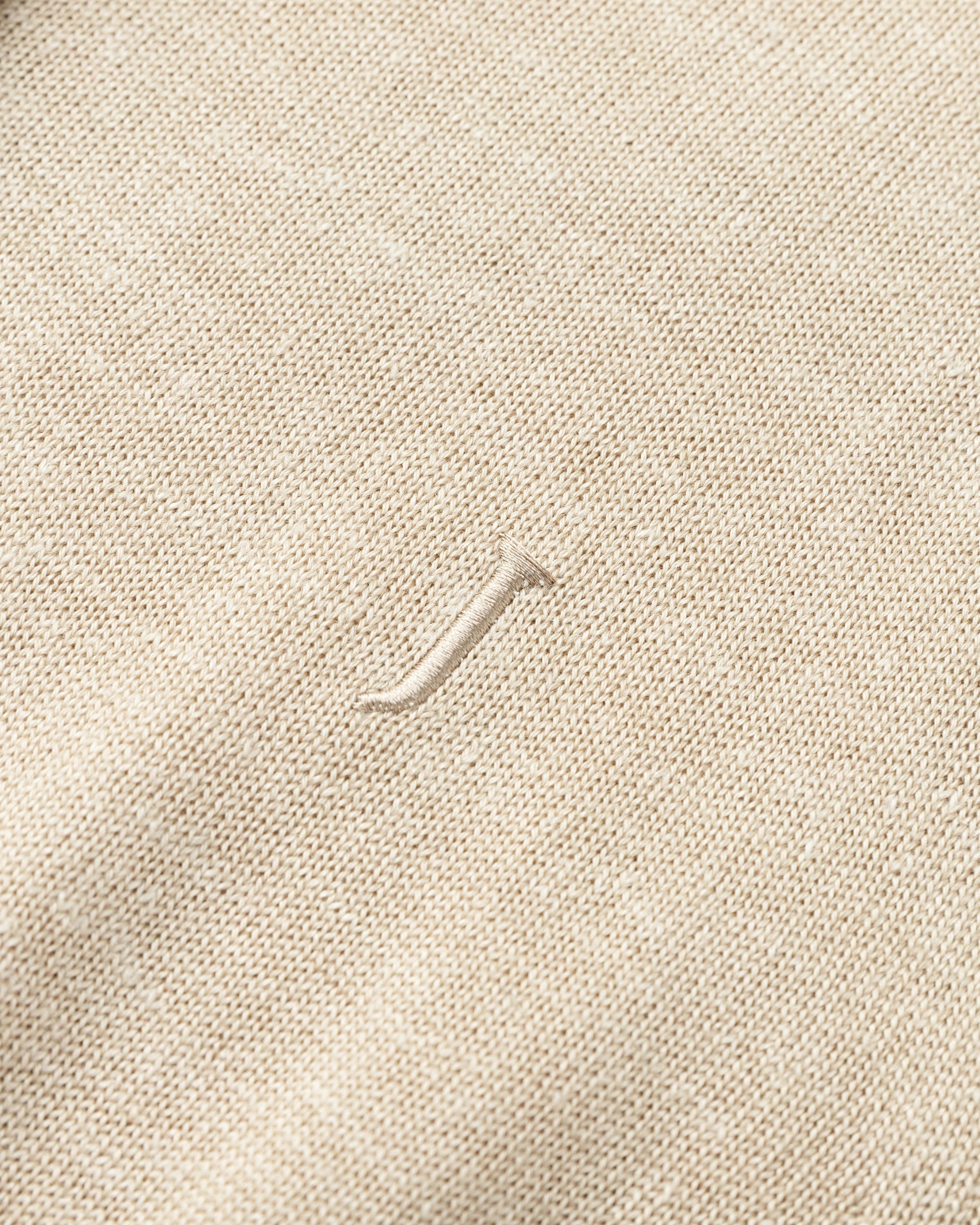 Flat lay of Liora Knitted Hemp Cardigan (beige), showing knit structure and embroideries finishing.
