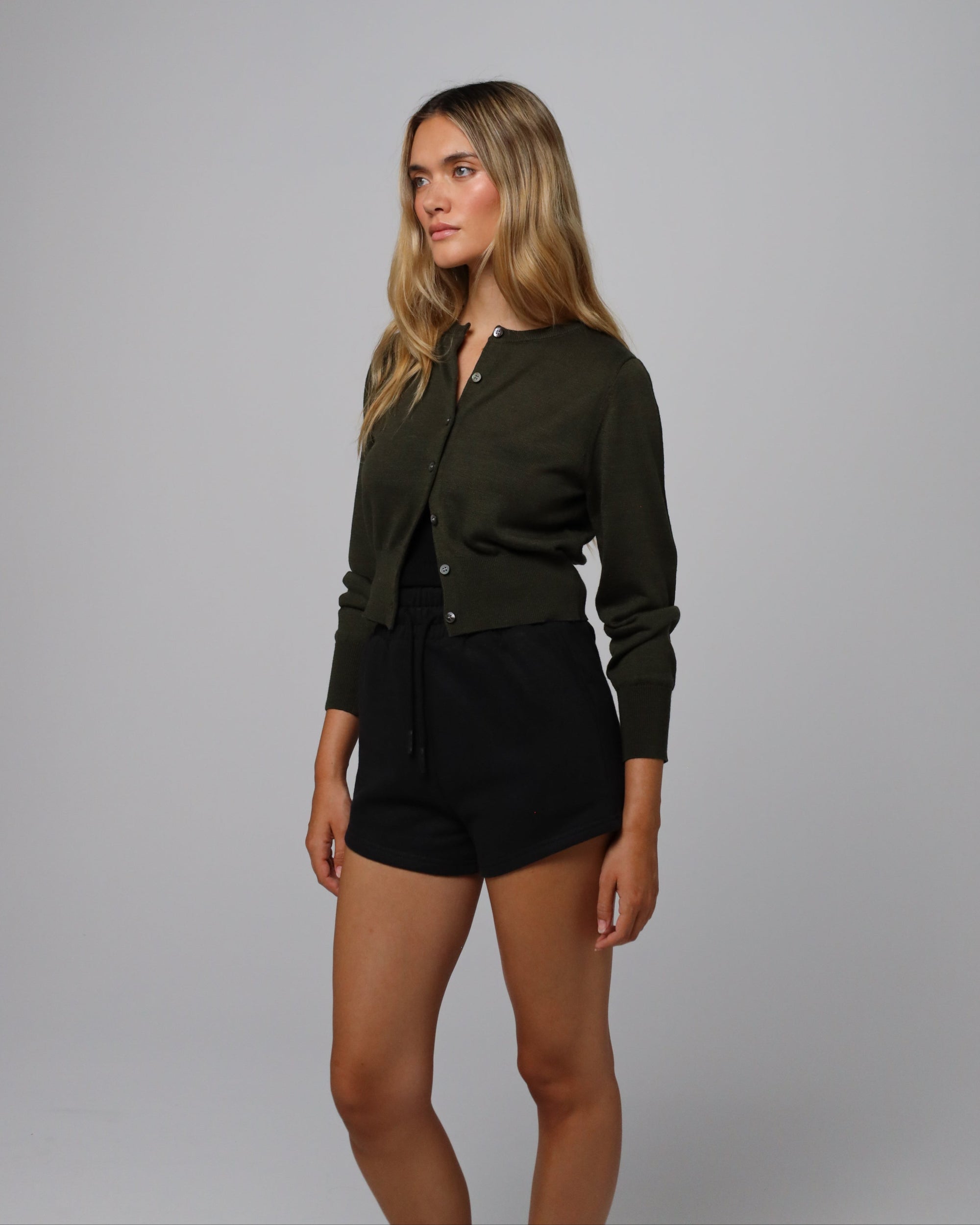 Detail shot of corozo button placket and tailored rib finish on Liora Knitted Hemp Cardigan (camo green).