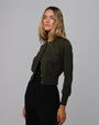 Woman wearing Juana Liora Knitted Hemp Cardigan in camo green merino–silk–hemp blend, styled for sustainable everyday wear.