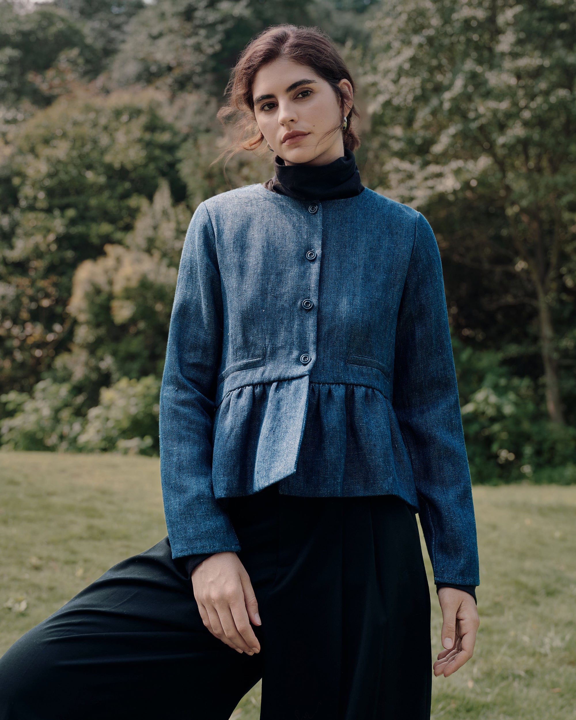 Refined casual: Peplum Jacket (blue denim) over Ossa Turtleneck (black) paired with denim for a sculptural, textured mix.