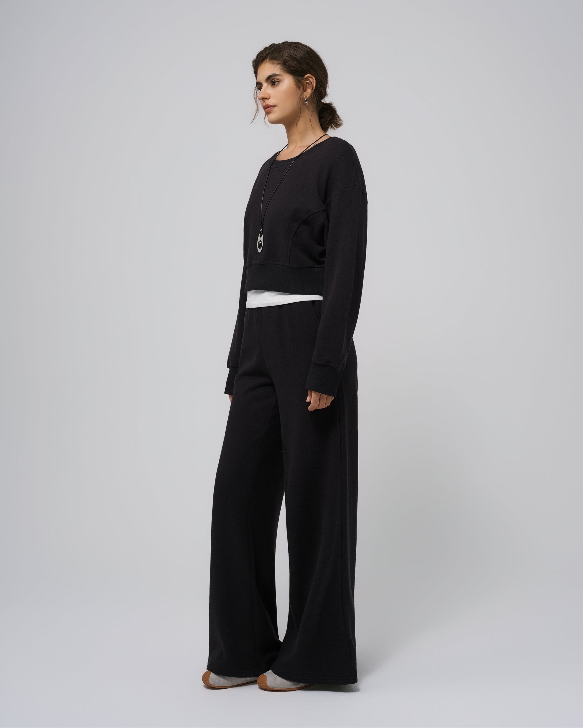 Model wearing coordinated black fleece set; straight-on front view.