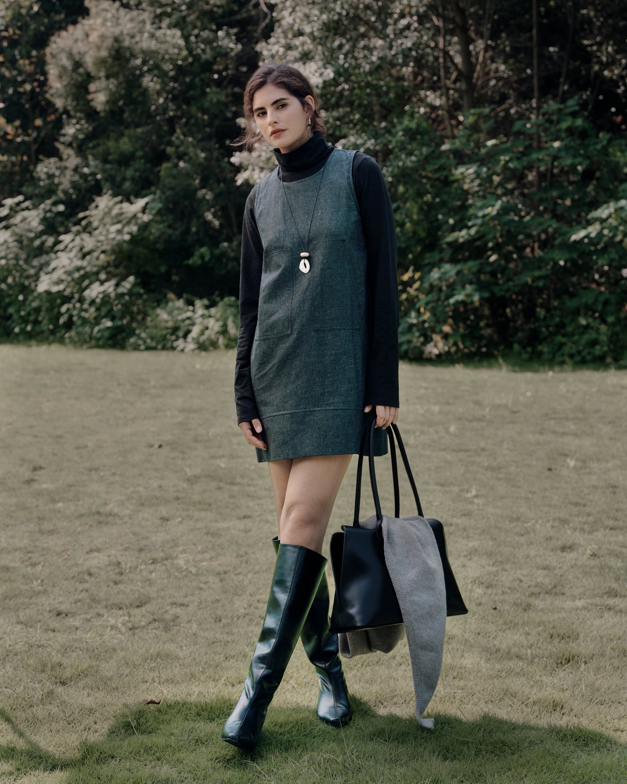Model wearing Juana Hemp Essentials Mockneck (black, hemp–organic cotton blend) layered with Denim Atelier Shift Dress (black denim, hemp–organic cotton denim), styled for sustainable everyday wear.