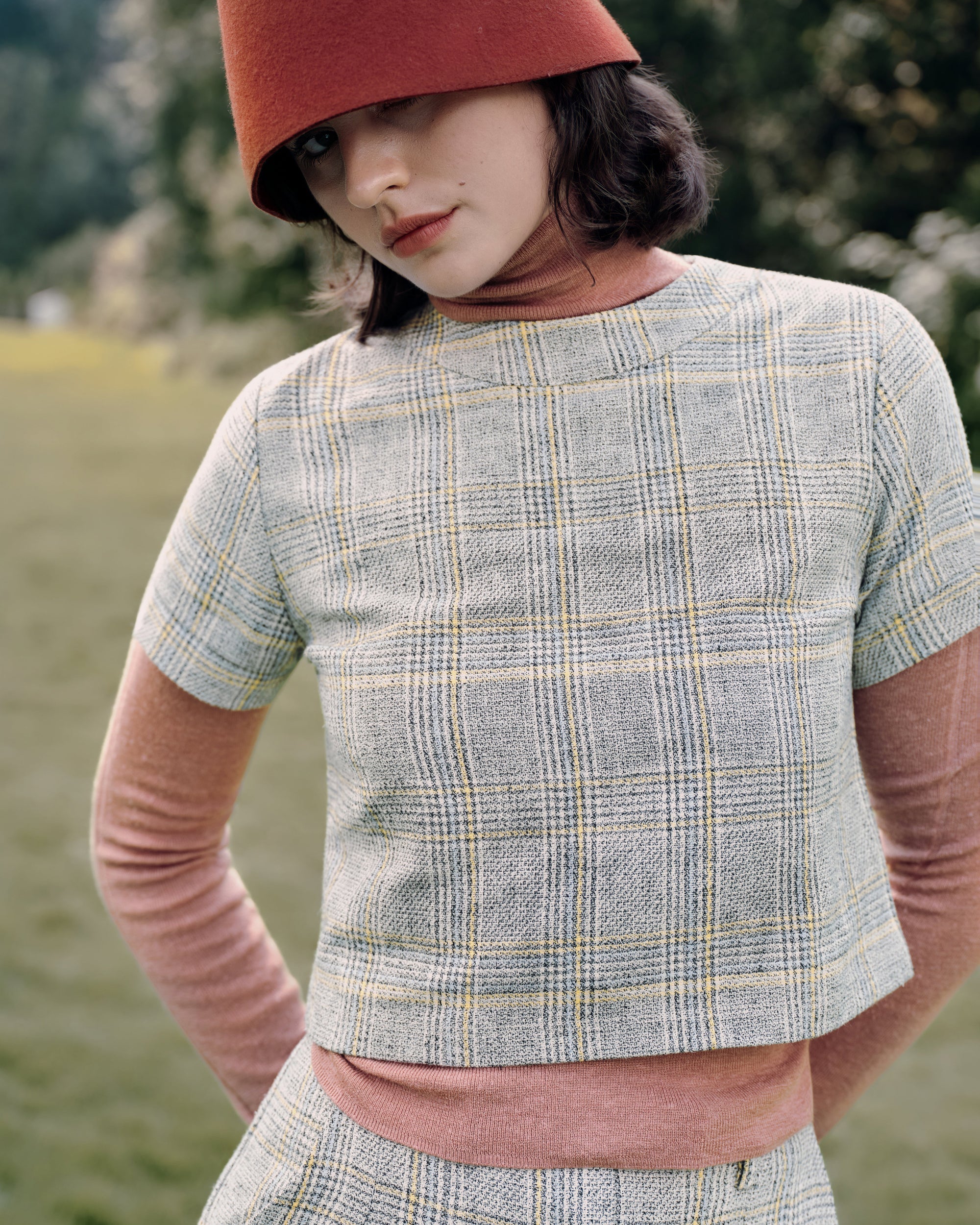 Detail shot of Ossa turtleneck collar (Mocha Mousse) layered beneath the Plaid Theory Top’s clean neckline (yellow–grey plaid); fine seaming visible.