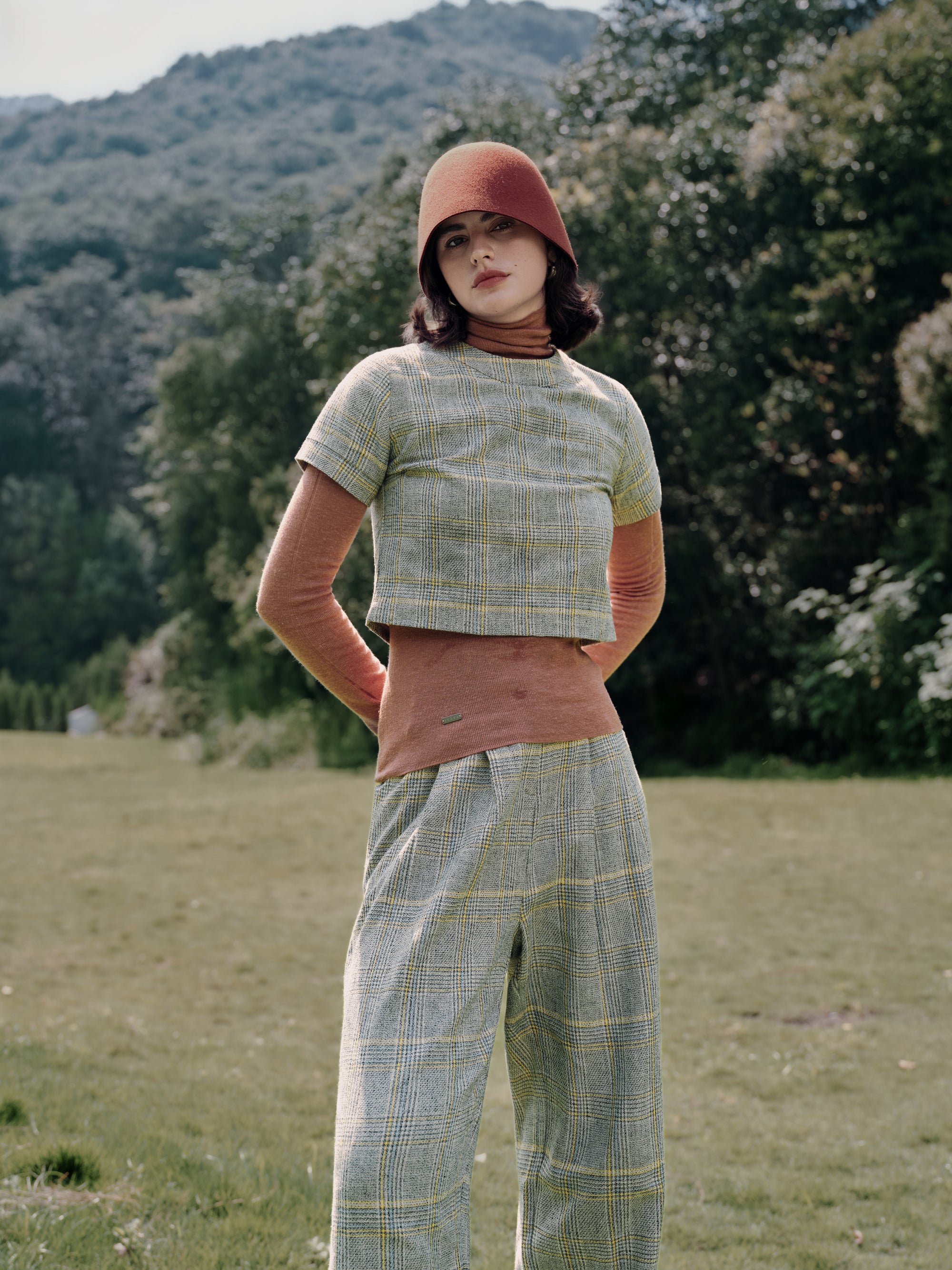 Layered styling: Ossa Turtleneck (Mocha Mousse) under Plaid Theory Top (yellow–grey plaid) with Plaid Theory trousers for minimalist polish.