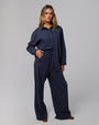 Woman wearing Juana Lyricist High Rise Pull-on Pants in an indigo blue hemp–Tencel™ twill blend, styled for sustainable everyday wear.