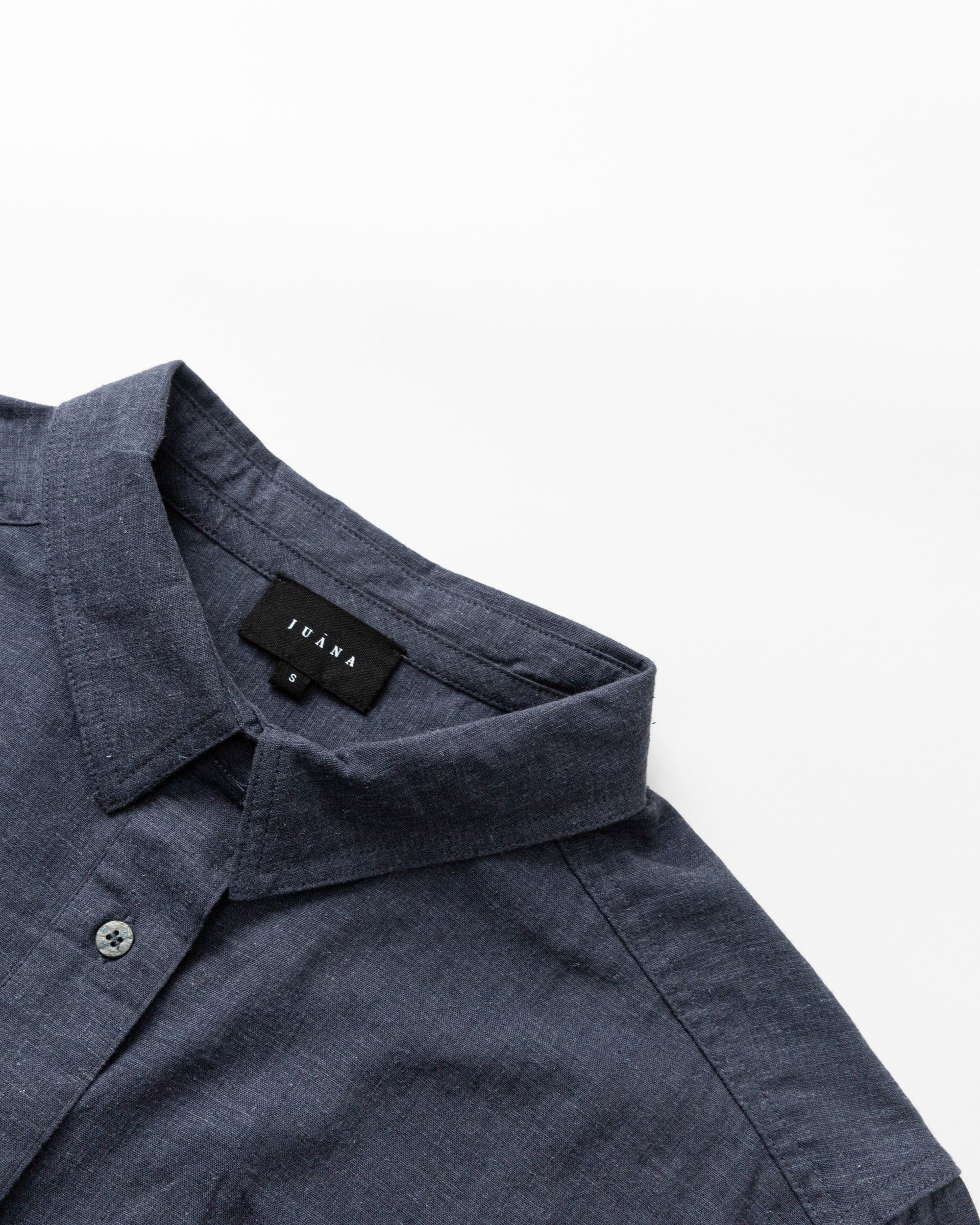 Detail shot of corozo buttons and stitching on the Lyricist Oversized Shirt in indigo blue.
