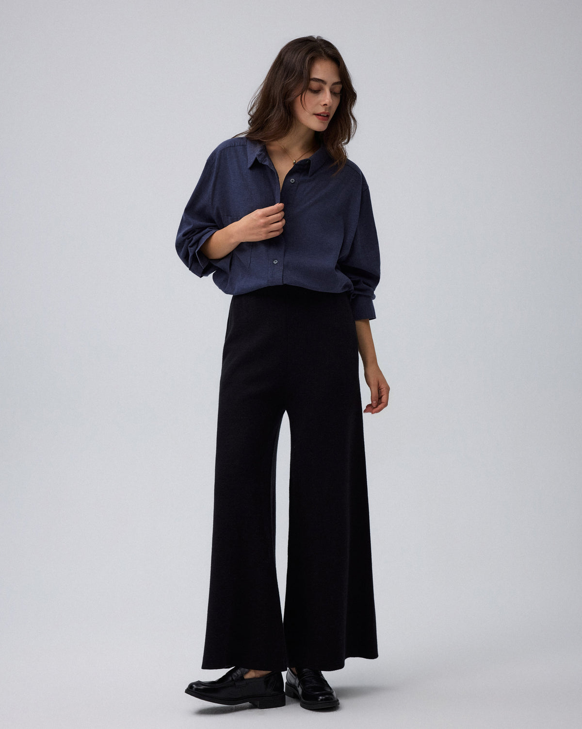 Juana Mid-Rise Cropped Pants in Black (merino wool–hemp–silk) styled with a blouse and one deep hidden side pocket visible.