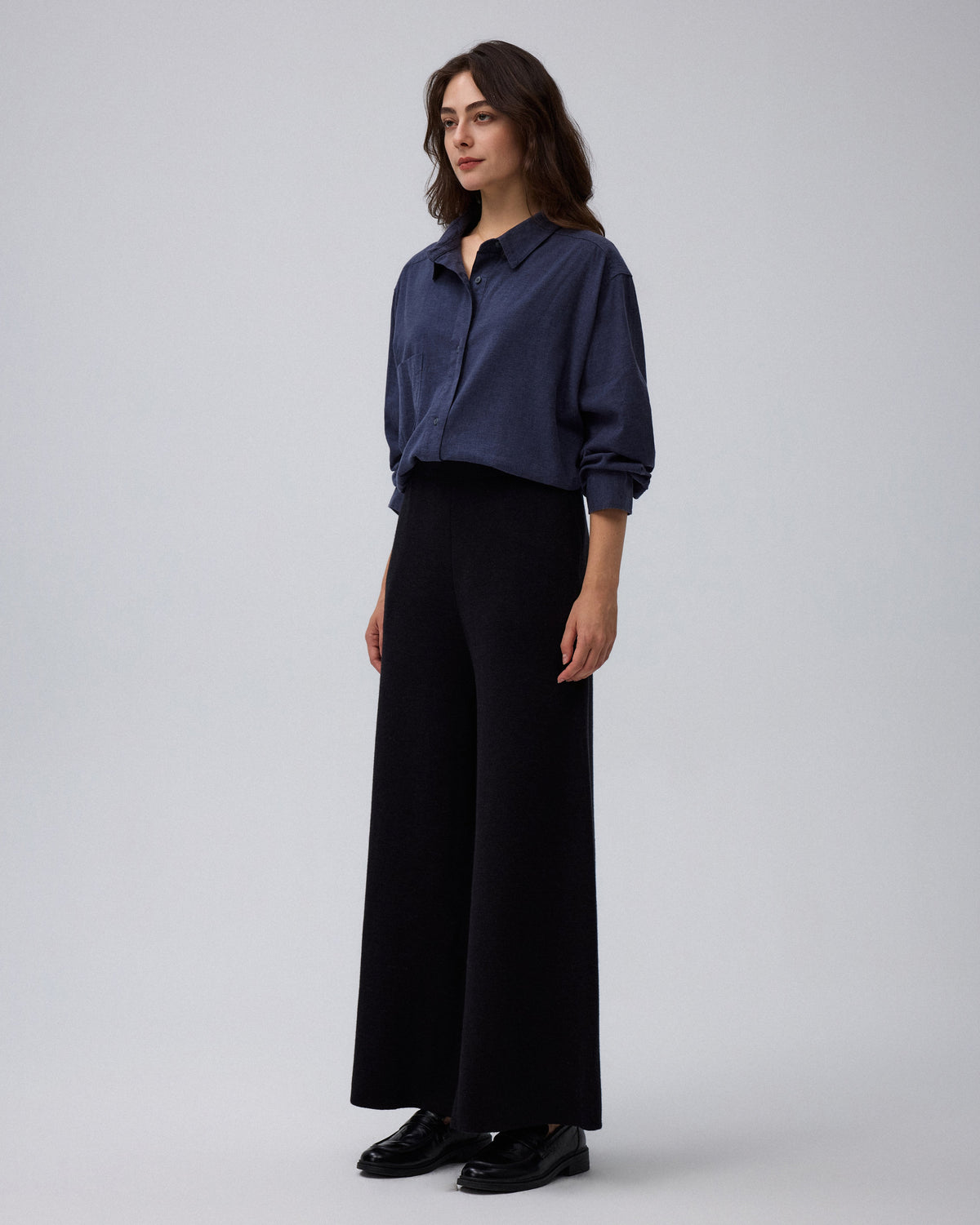 Juana Mid-Rise Cropped Pants in Black (merino wool–hemp–silk) shown in side profile with the mid-rise waist and wide leg visible.