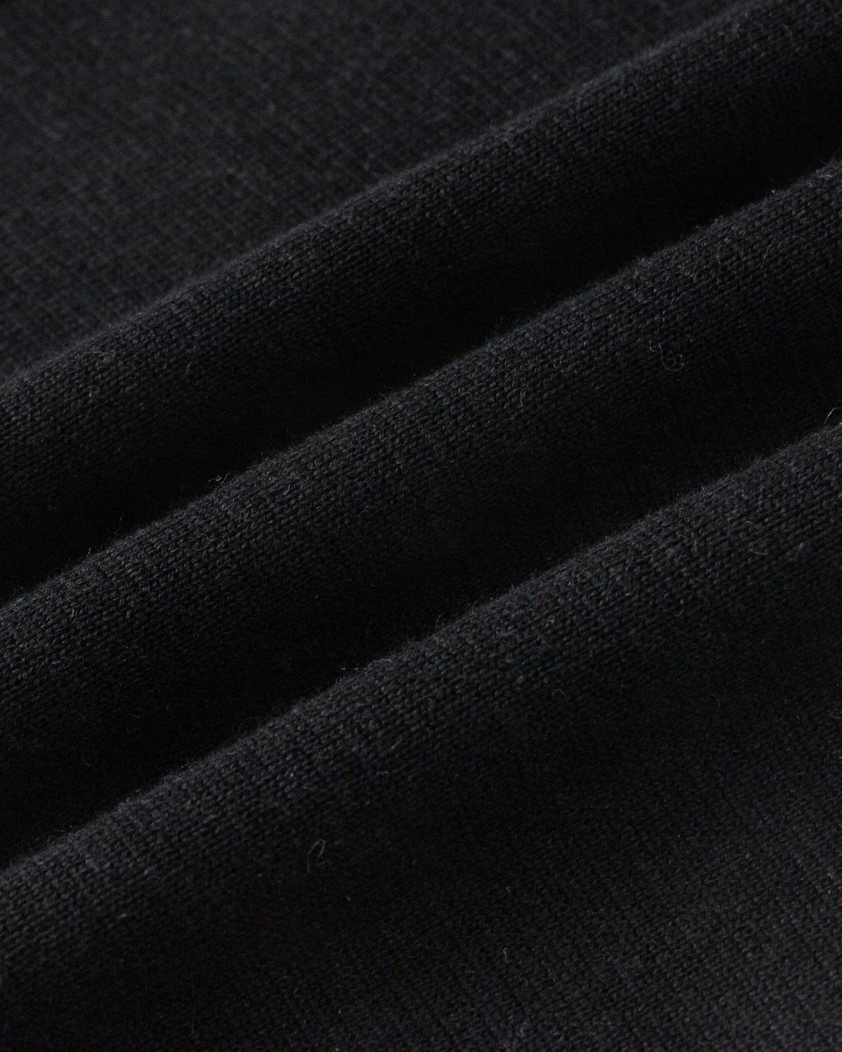 Juana Mid-Rise Cropped Pants in Black (merino wool–hemp–silk) shown in a close-up of the heavyweight sweater-knit texture.