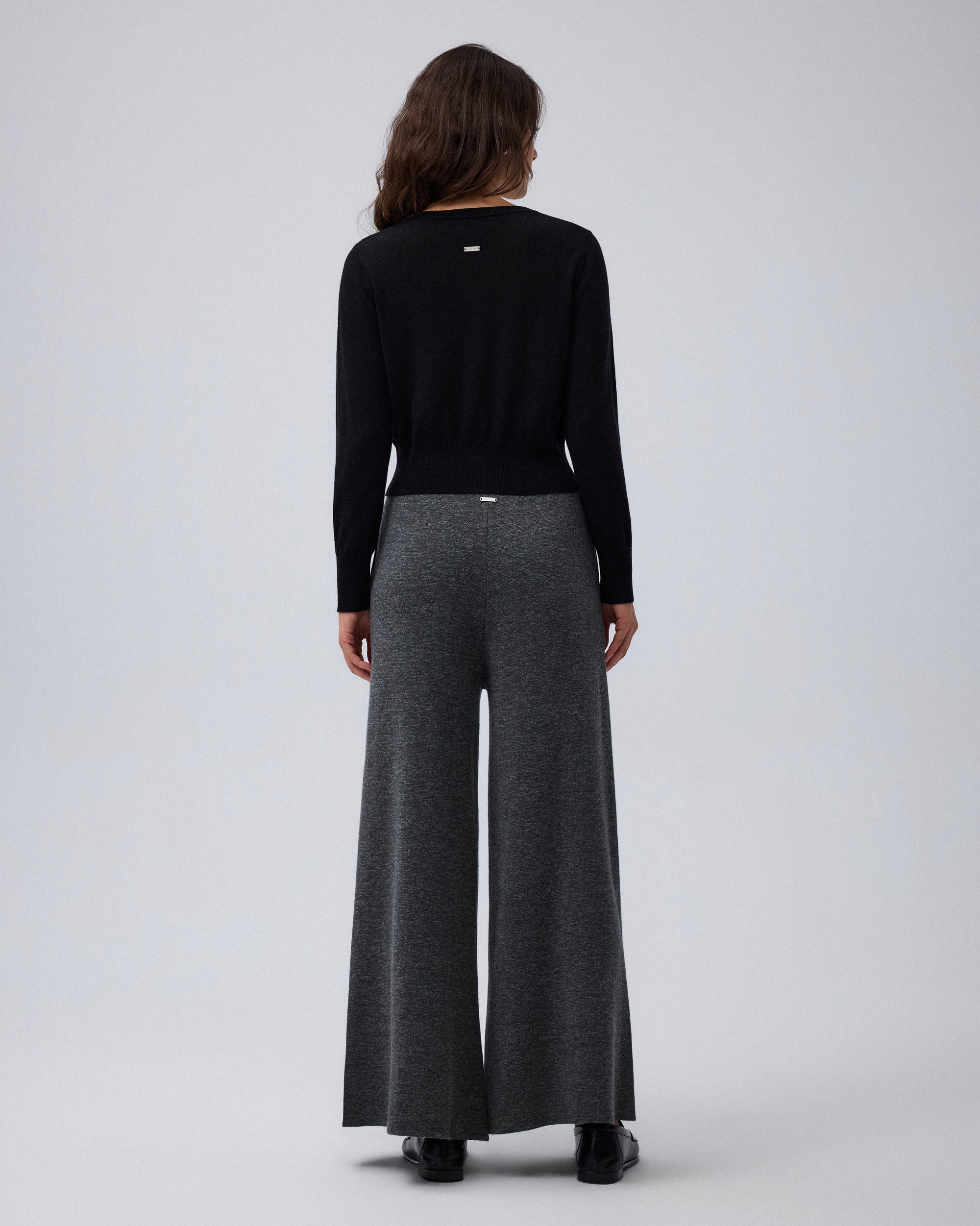 Juana Mid-Rise Cropped Pants in Charcoal (merino wool–hemp–silk) shown on a model from the back with a clean sweater-knit drape.