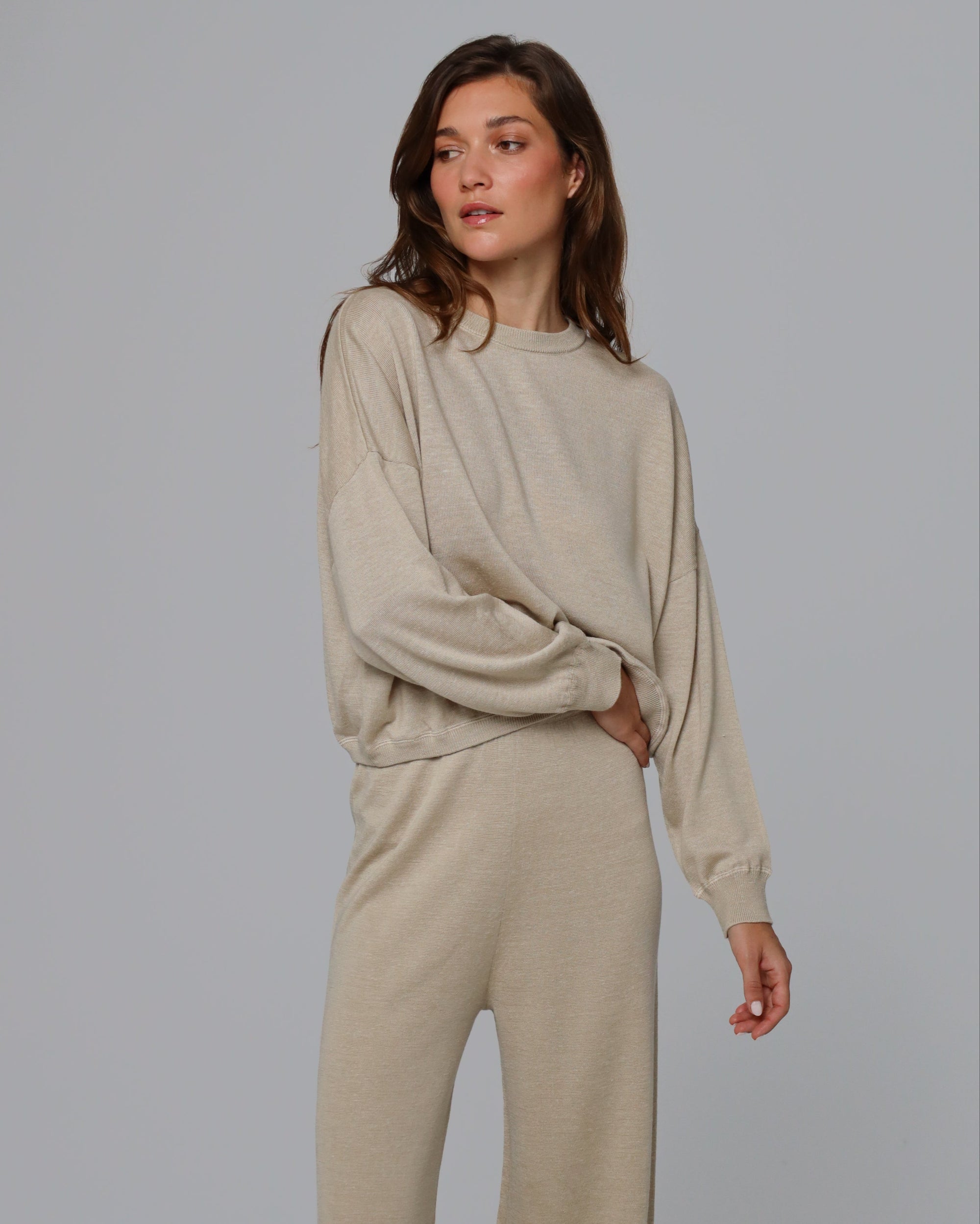 Woman wearing Juana Nilo Knitted Hemp Crewneck in beige merino–silk–hemp blend, styled for sustainable everyday wear.