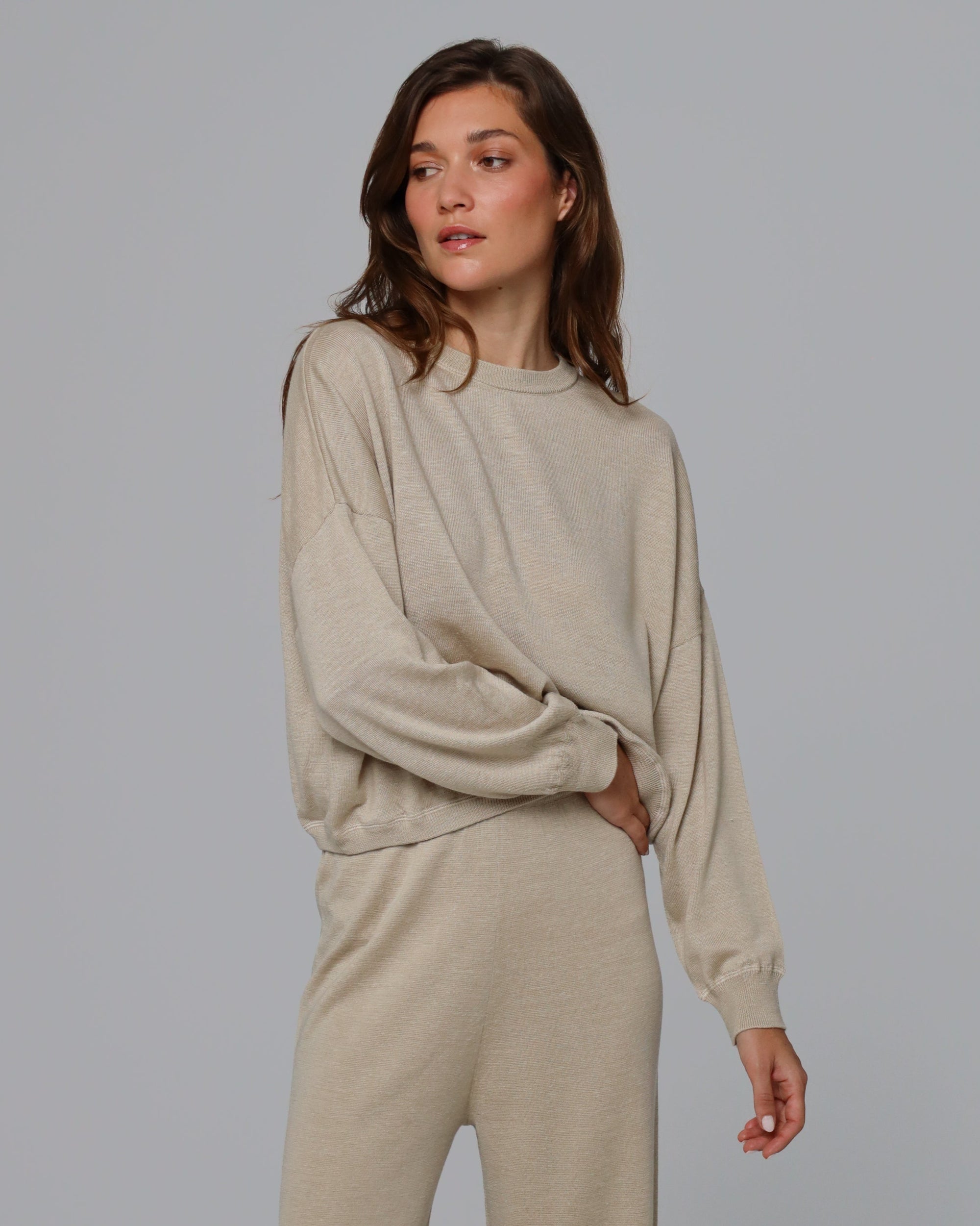 Woman wearing Juana Nilo Knitted Hemp Crewneck in beige merino–silk–hemp blend, styled for sustainable everyday wear.