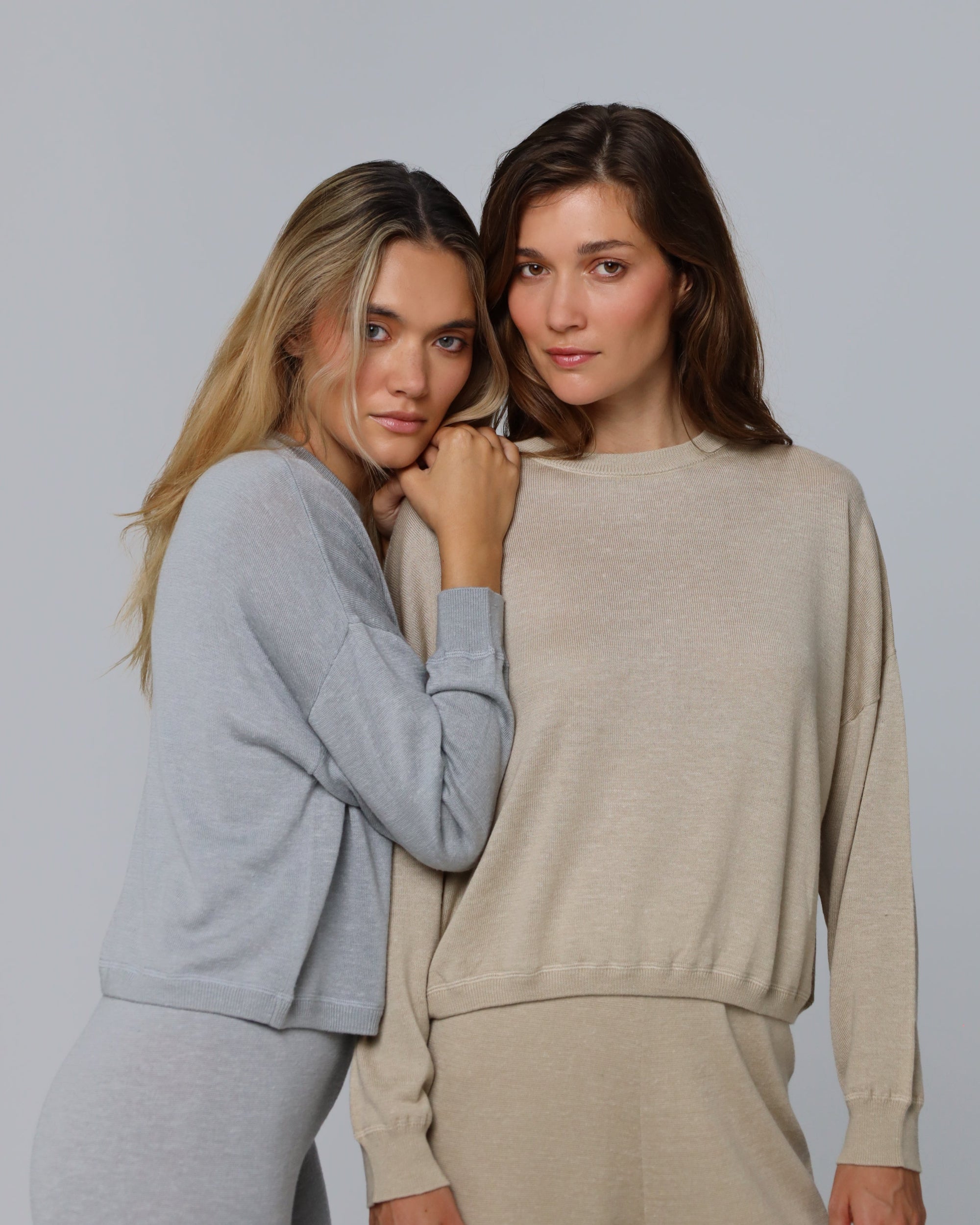 Two women wearing Nilo Knitted Hemp Crewneck (heather gray and beige) in an elevated casual outfit.