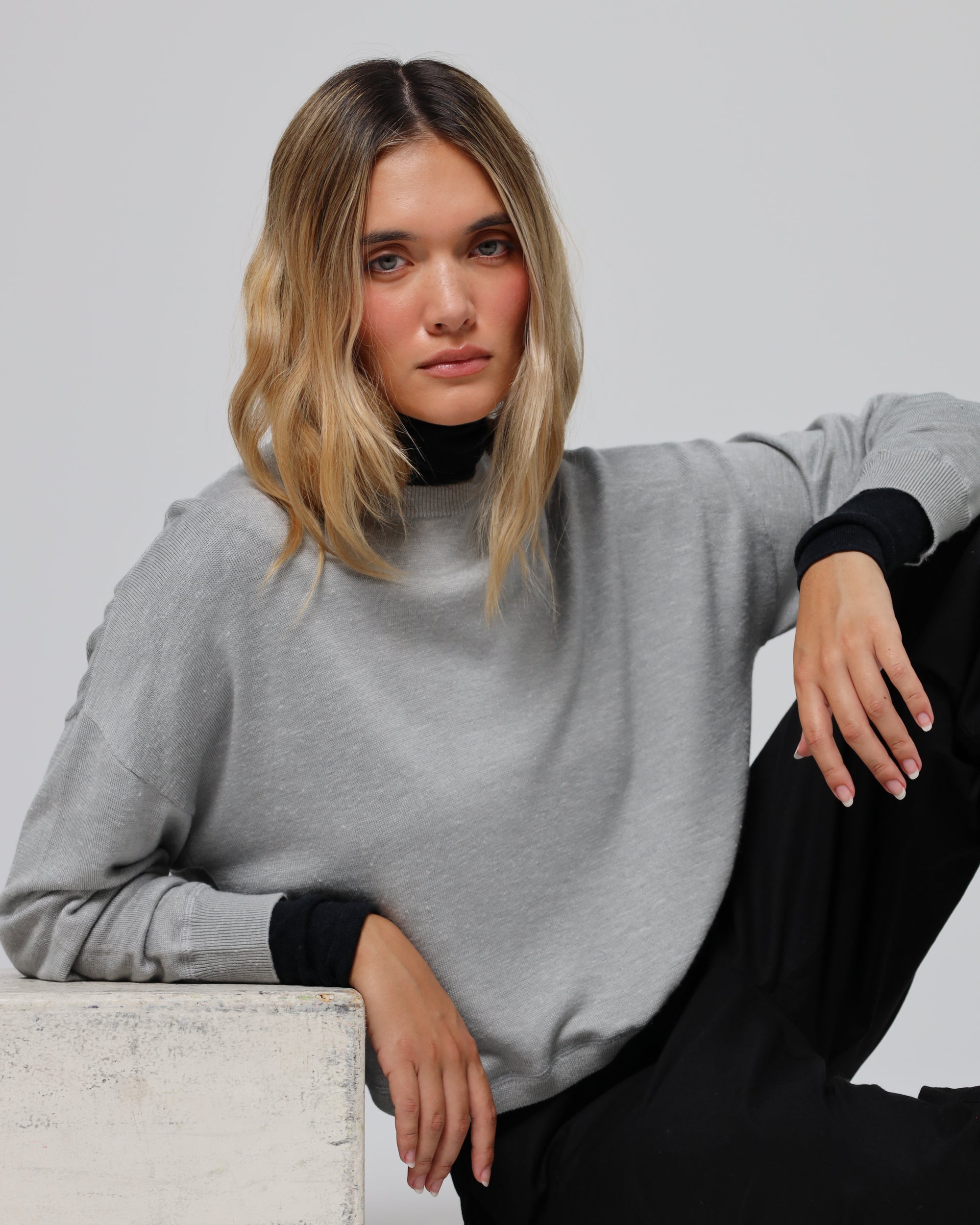 Model styling Nilo Knitted Hemp Crewneck (heather gray) with relaxed, polished separates.