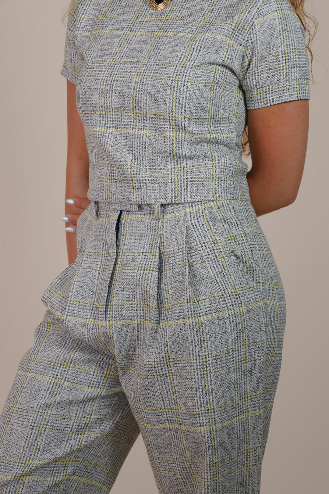 Woman wearing Juana Plaid Theory High Rise Trousers made from hemp and organic cotton with a tailored plaid design.