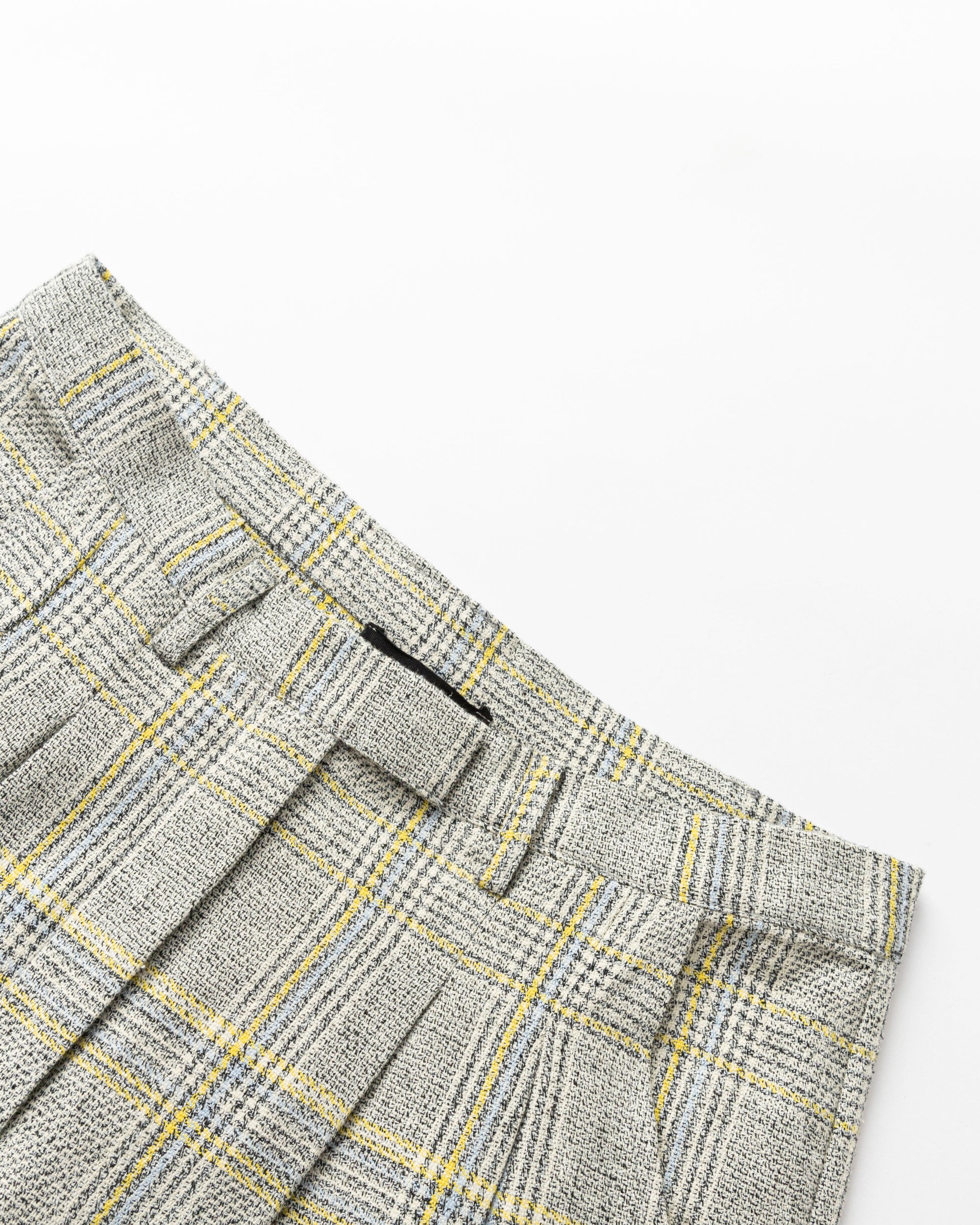 Detail shot of corozo button and waistband on Plaid Theory High Rise Trousers (yellow-grey plaid).