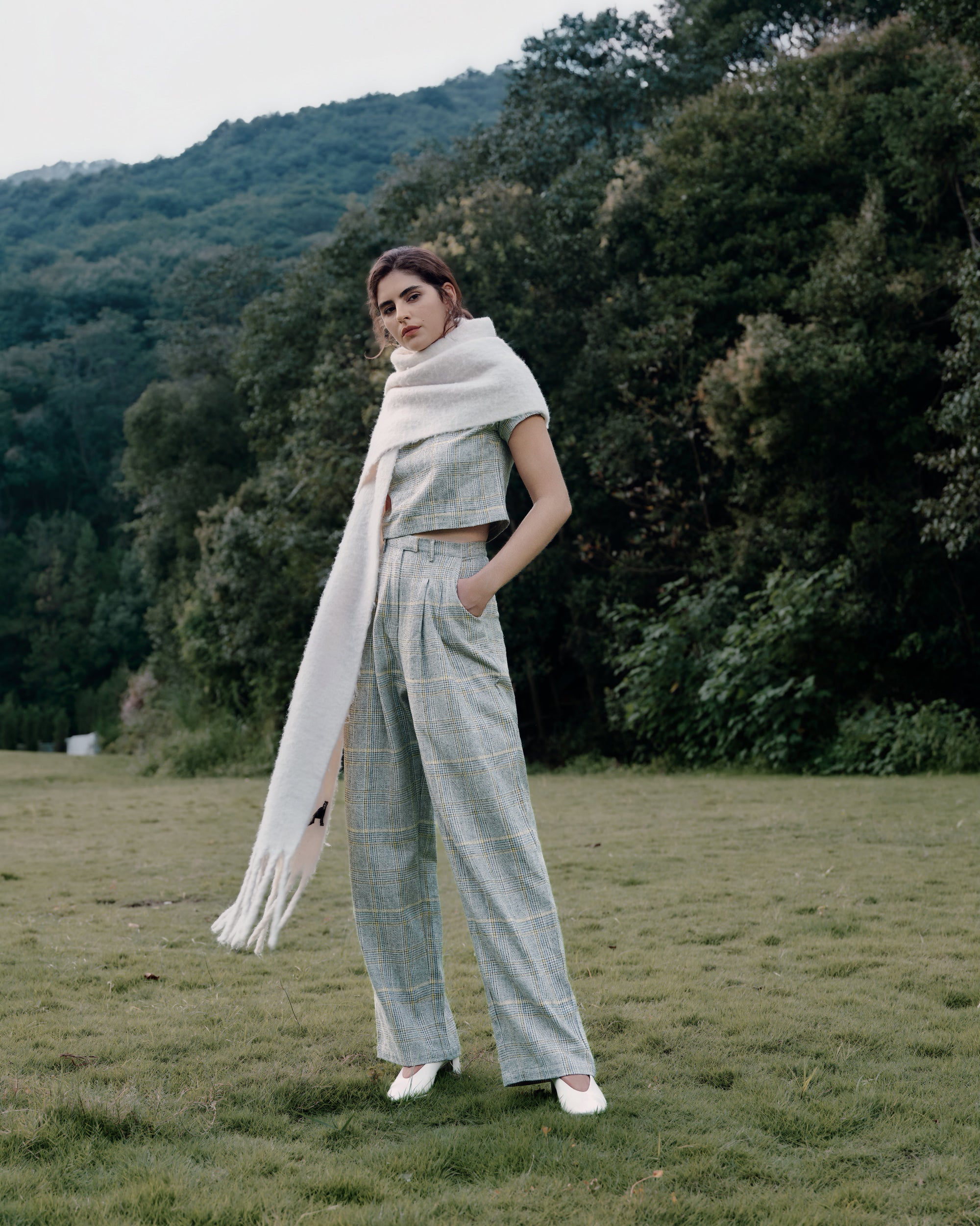 Woman wearing Juana Plaid Theory High Rise Trousers in yellow-grey plaid hemp–organic cotton blend, styled for sustainable everyday wear.