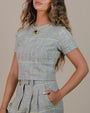 Woman wearing Juana Plaid Theory Top in hemp and organic cotton with short sleeves and a tailored plaid pattern.