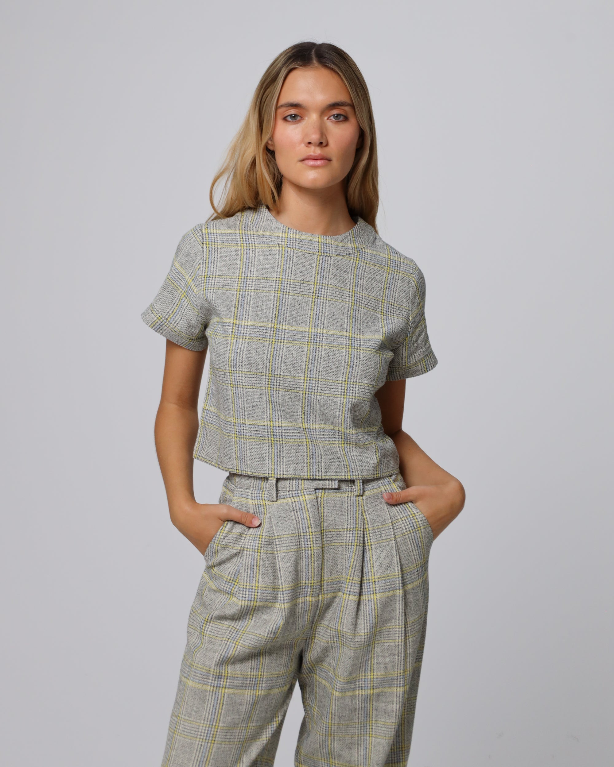 Woman wearing Juana Plaid Theory Top in yellow-grey plaid hemp–organic cotton blend, styled for sustainable everyday wear.