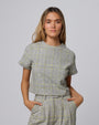 Woman wearing Juana Plaid Theory Top in yellow-grey plaid hemp–organic cotton blend, styled for sustainable everyday wear.