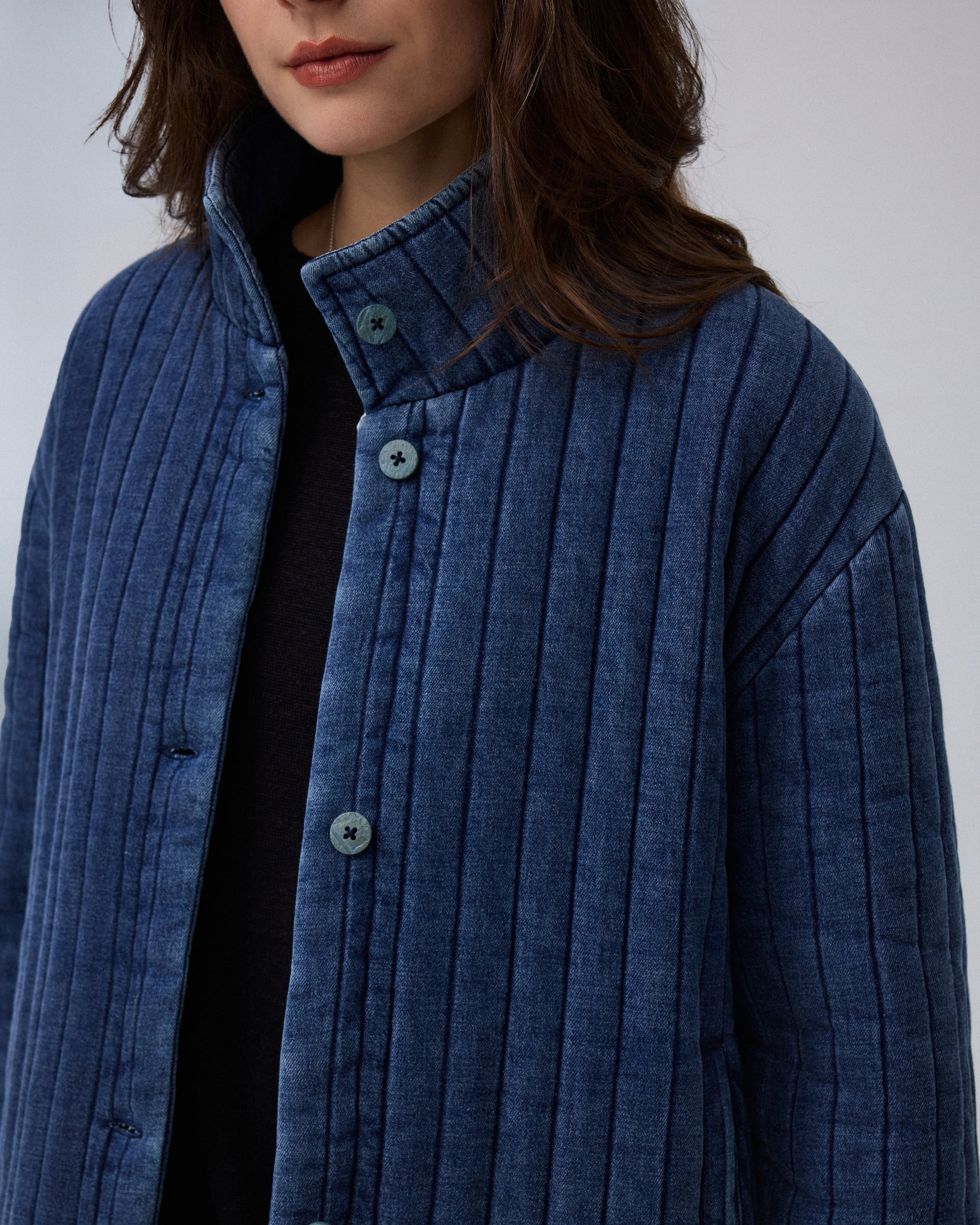 Juana Quilted Denim Jacket in Indigo Wash (organic cotton–hemp) model detail showing coconut buttons, soft-washed texture and hidden pocket construction.