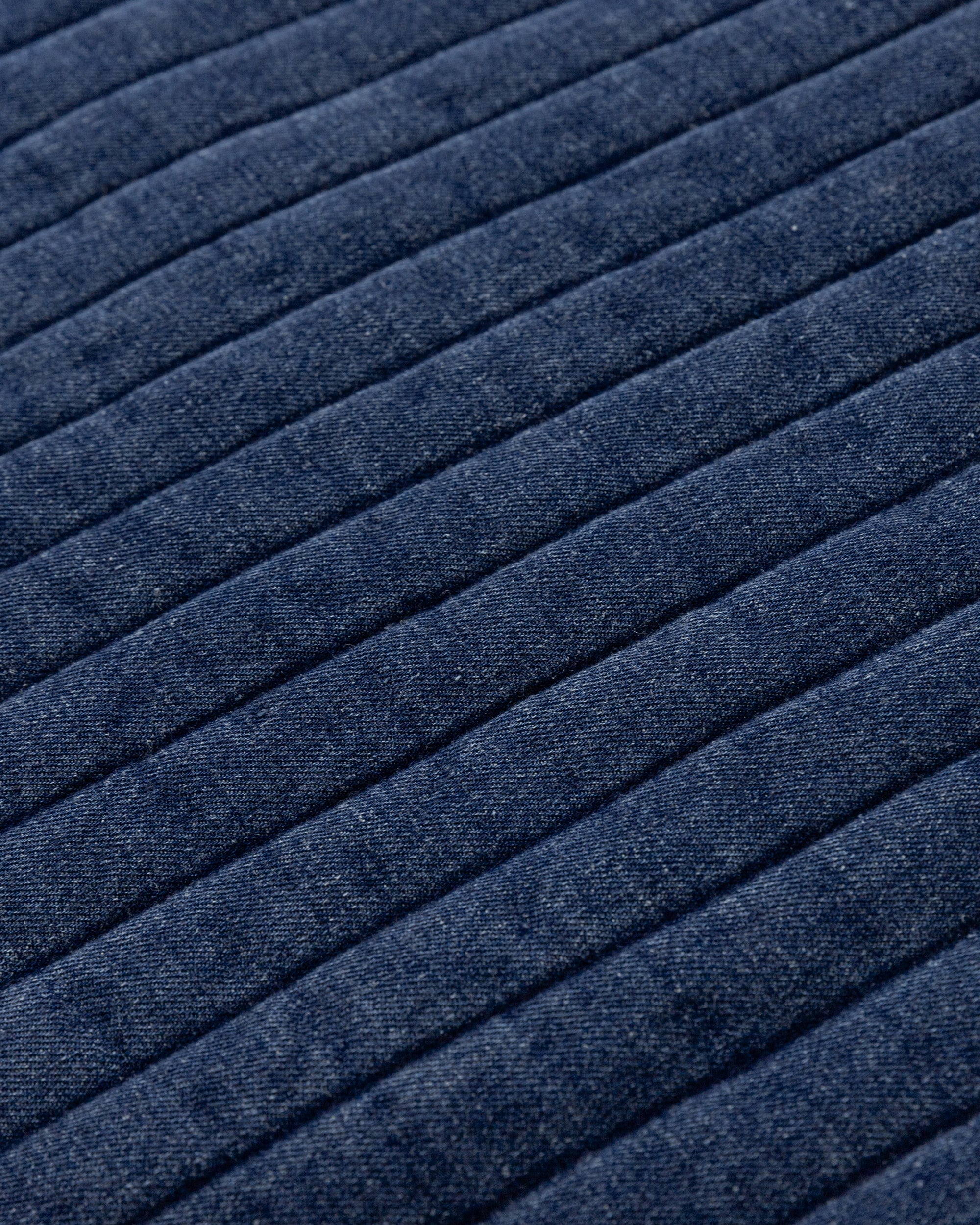 Juana Quilted Denim Jacket in Indigo Wash (organic cotton–hemp) textile close-up showing the soft-washed denim texture and quilted surface.