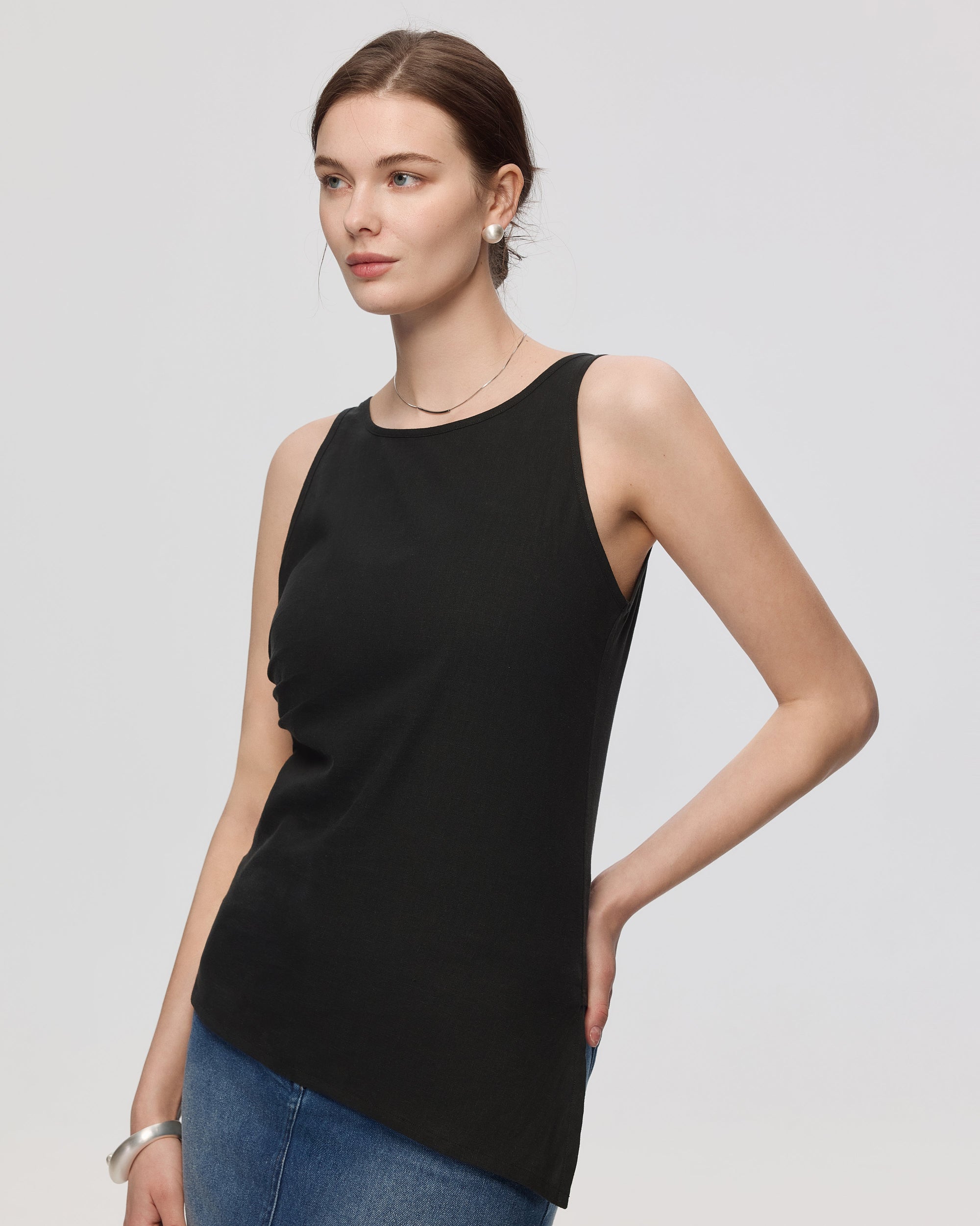 Juana Sienna Pleated Tank black (hemp–cotton) on model showing asymmetrical hem and sleeveless fit