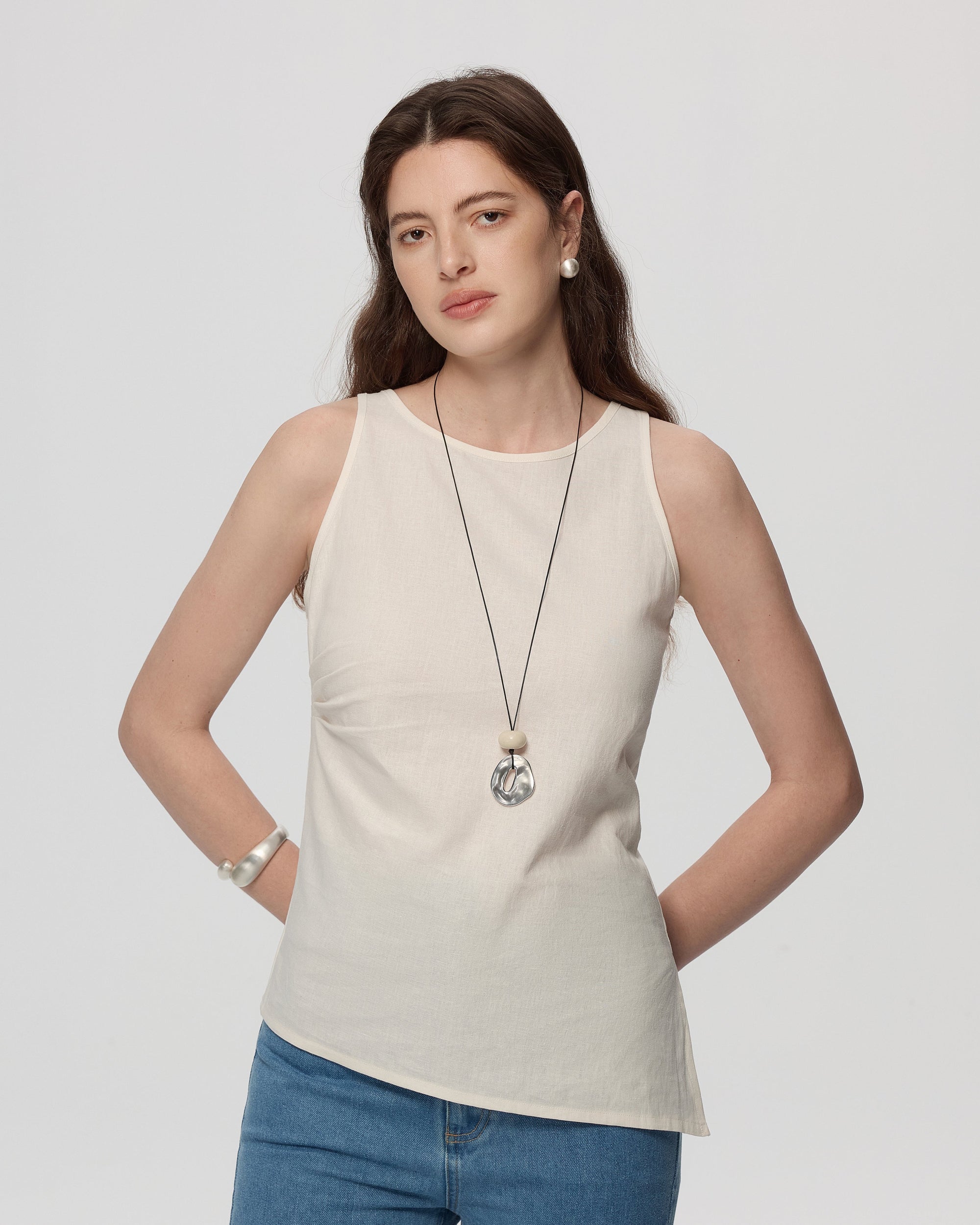 Juana Sienna Pleated Tank white (hemp–cotton) on model showing asymmetrical hem and sleeveless fit