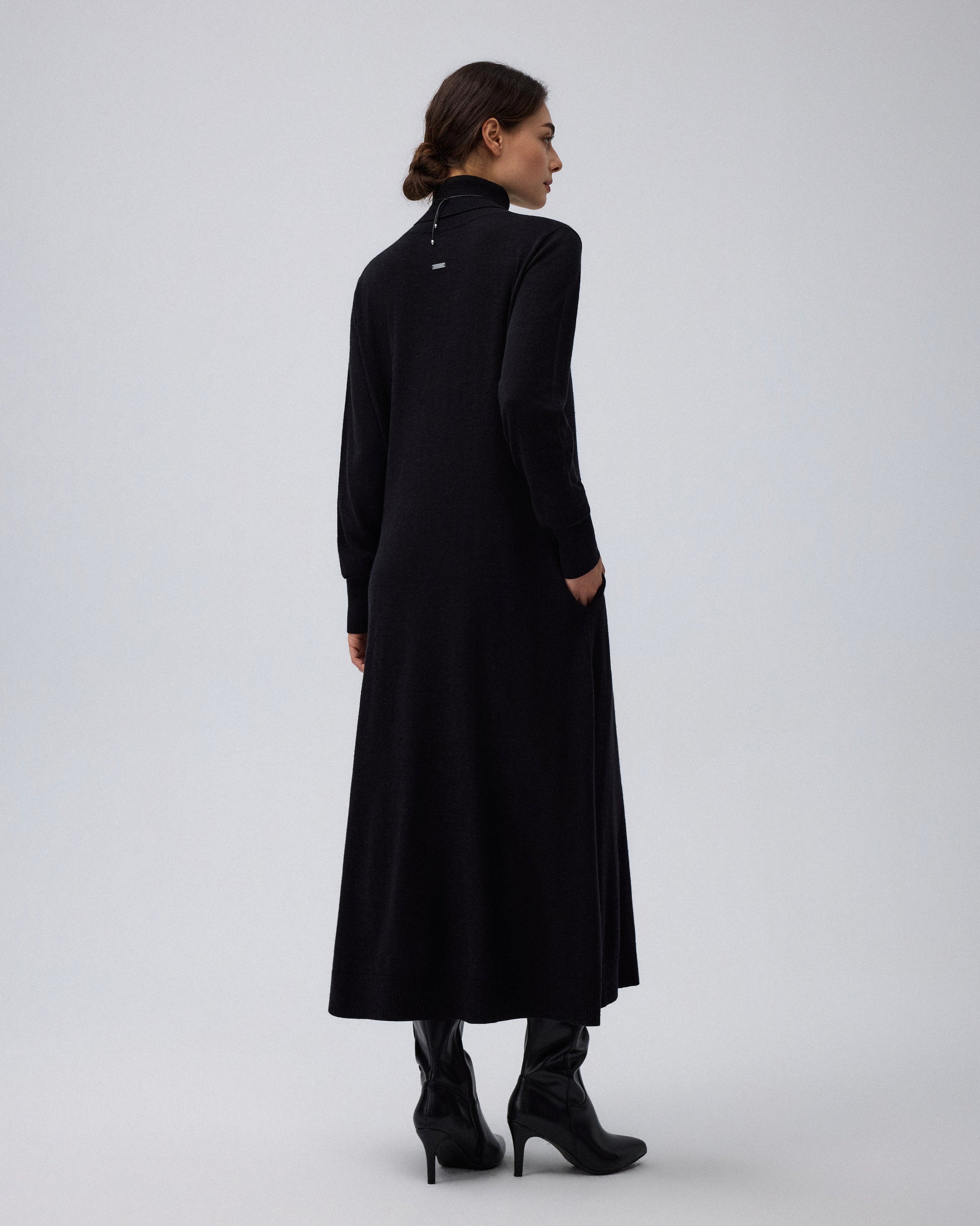 Juana Turtleneck Maxi Dress in Black (merino wool–hemp–silk blend) modeled from the back to show the flowing A-line maxi shape.