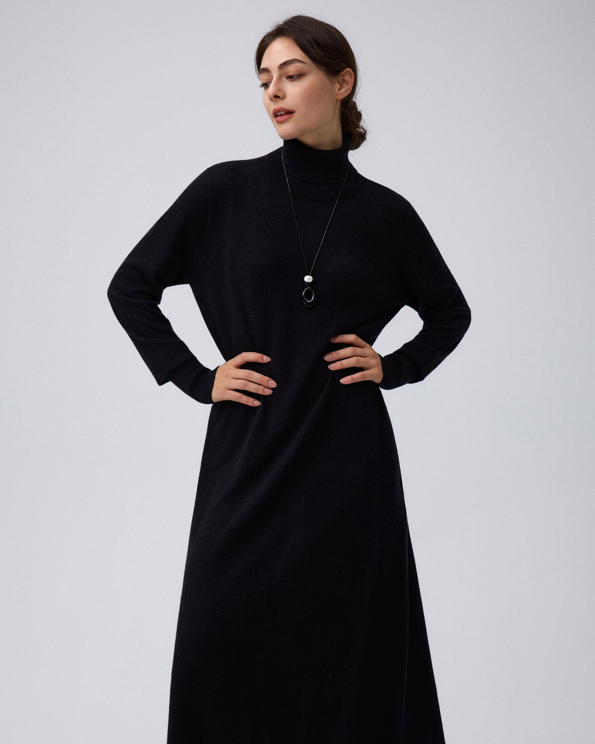 Juana Turtleneck Maxi Dress in Black (merino wool–hemp–silk blend) shown close up with the turtleneck, bishop sleeve, and pocket details.