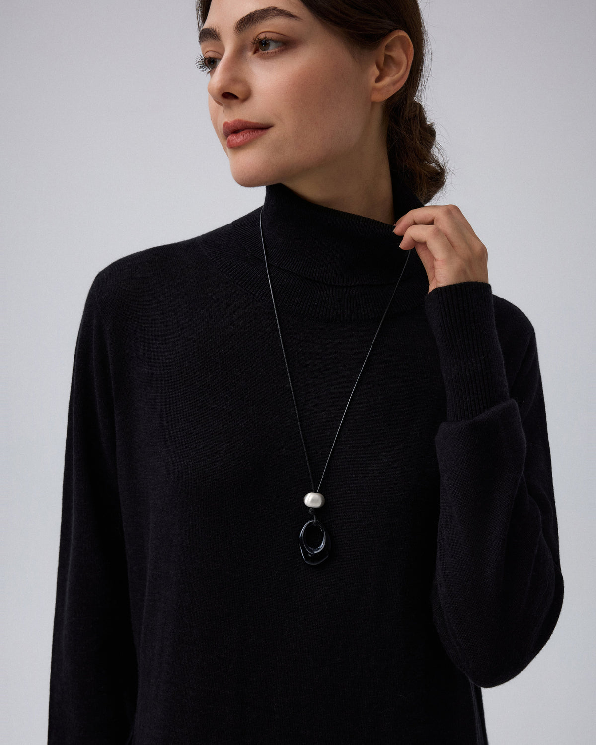 Juana Turtleneck Maxi Dress in Black (merino wool–hemp–silk blend) shown close up with the turtleneck, bishop sleeve, and pocket details.