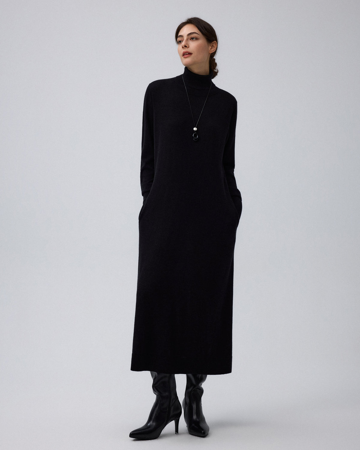Juana Turtleneck Maxi Dress in Black (merino wool–hemp–silk blend) styled for daytime wear with the turtleneck and A-line skirt visible.