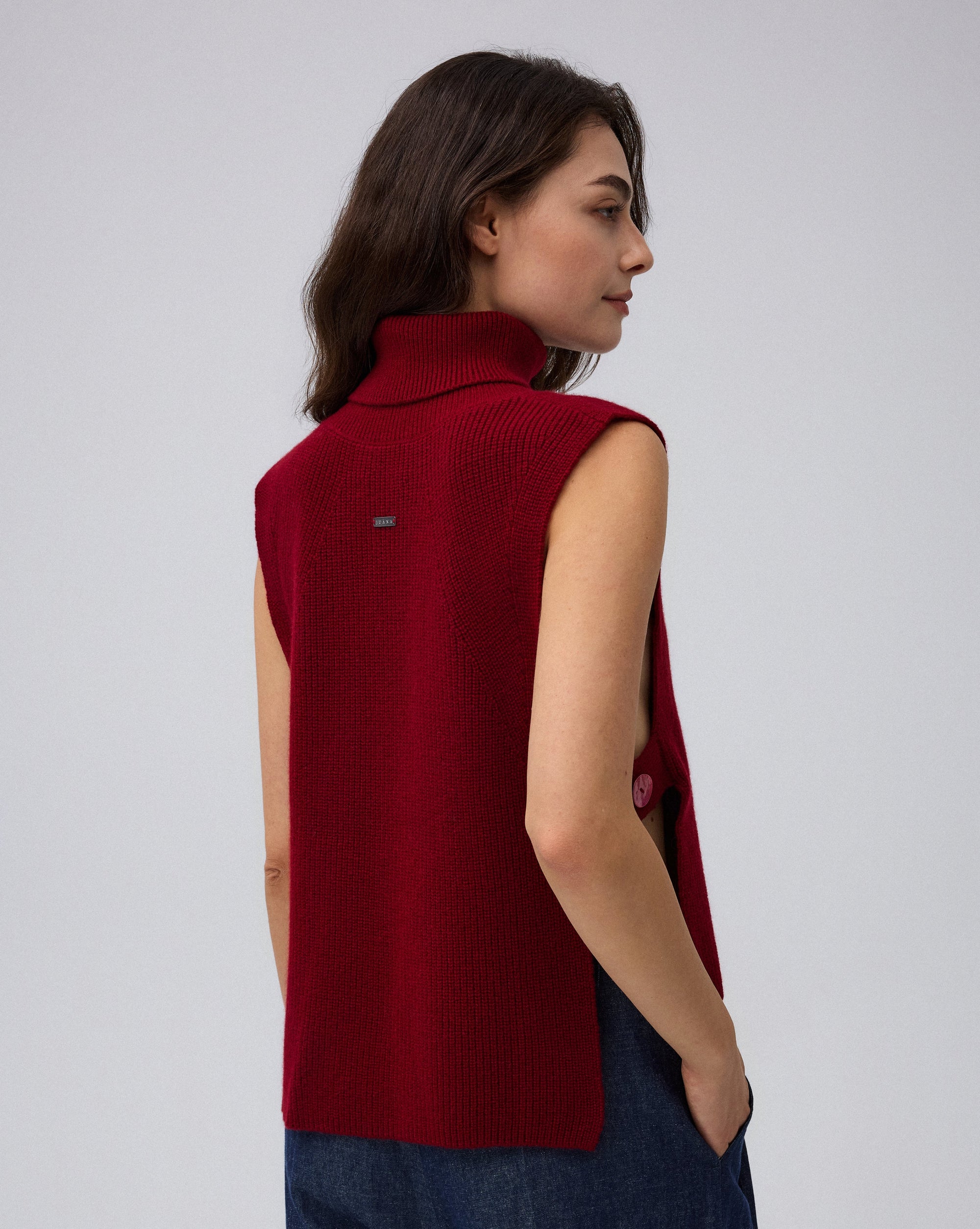 Juana Wool Cashmere Sweater Vest in Pomegranate (wool–cashmere) worn in a back view showing the stepped hem.
