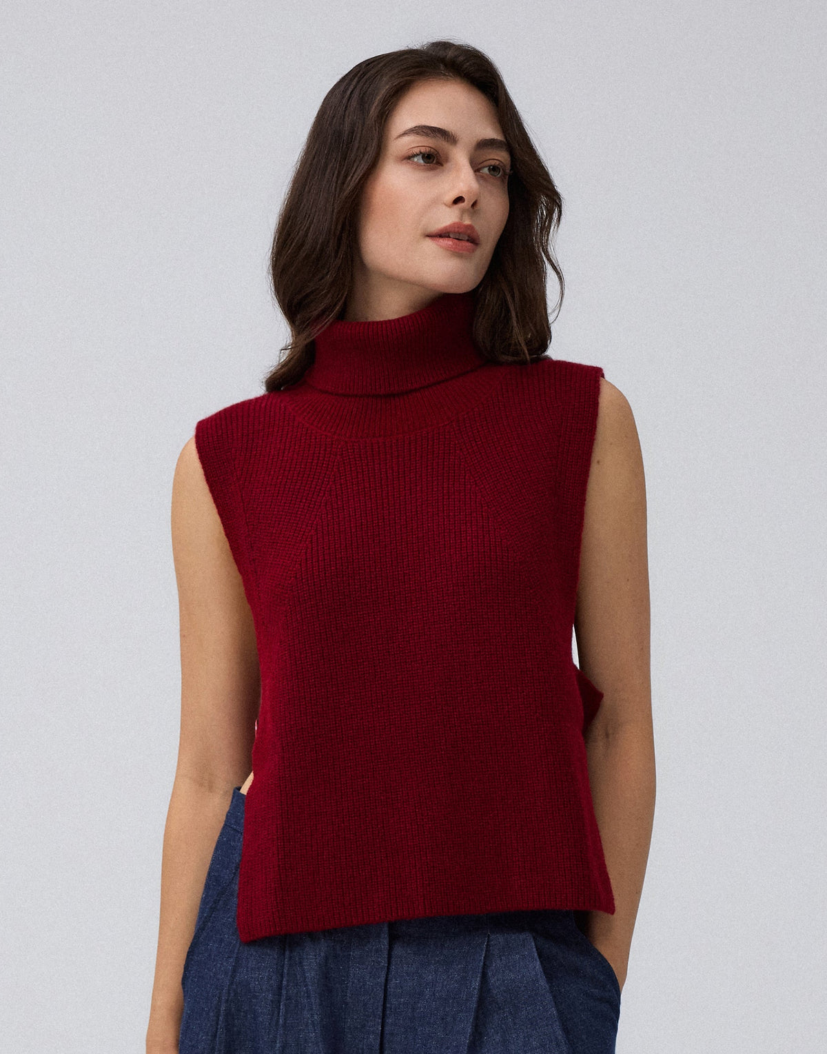 Juana Wool Cashmere Sweater Vest in Pomegranate (wool–cashmere) worn on a model in a front view with the open-side silhouette visible.