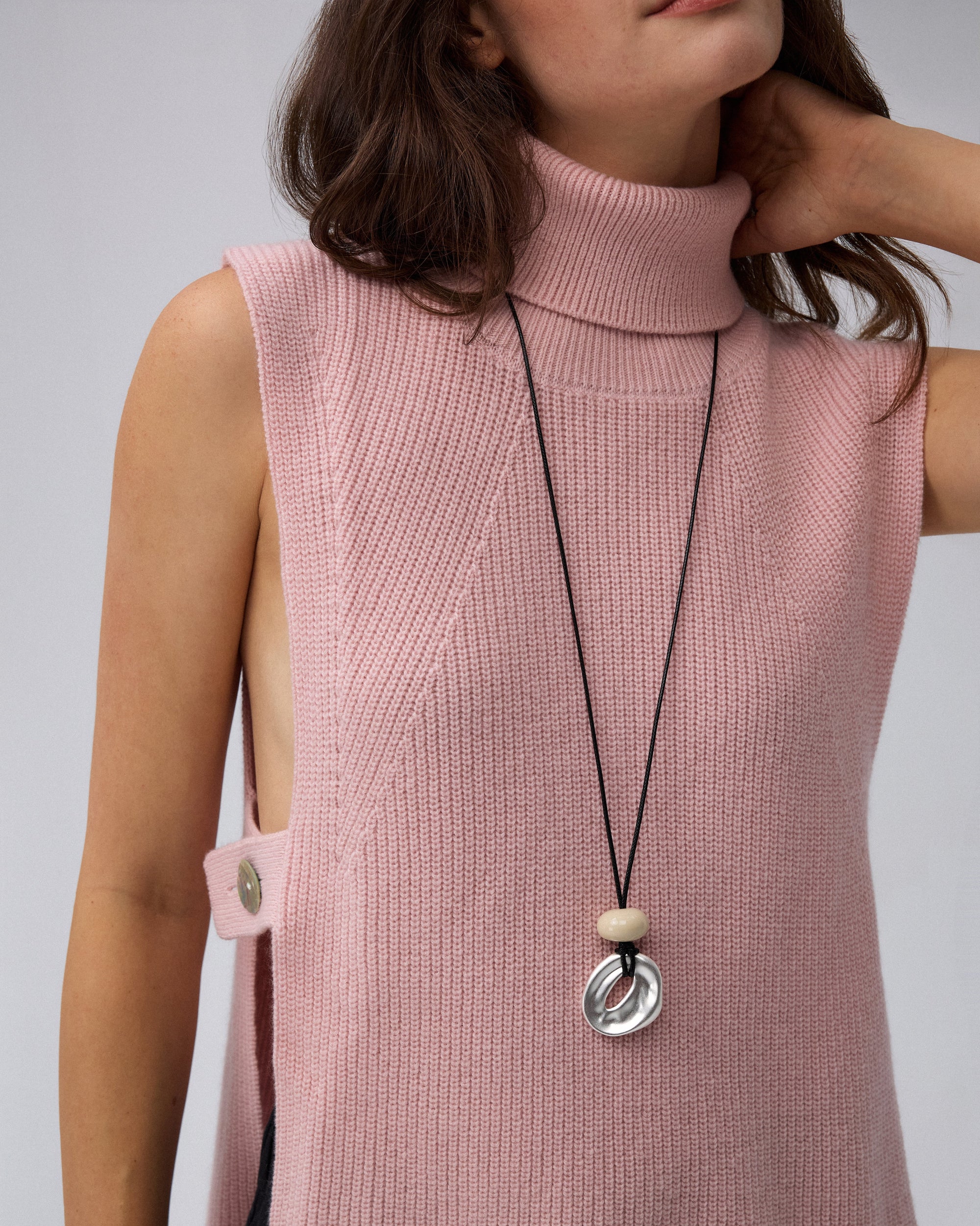 Juana Wool Cashmere Sweater Vest in Rose (wool–cashmere) shown in a close-up highlighting the abalone shell hardware and rib knit.