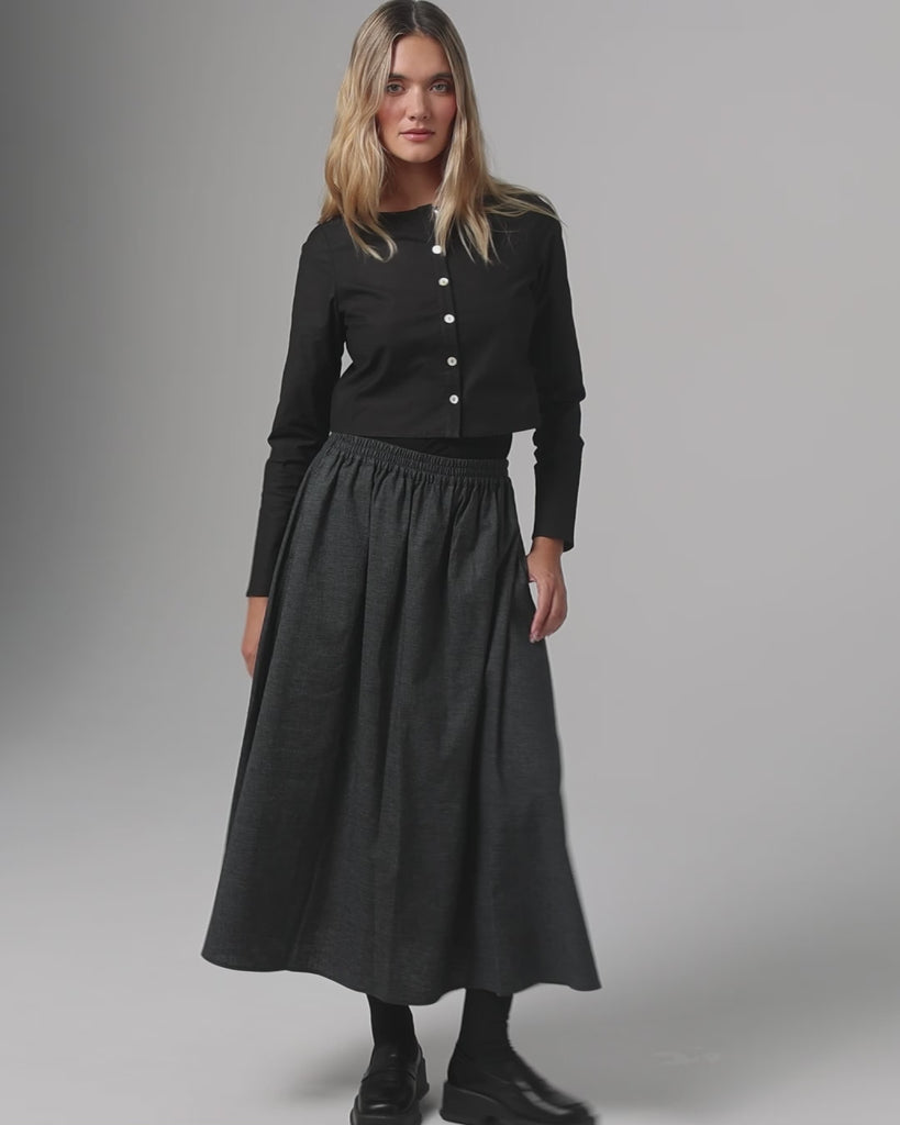 360-degree video of model wearing Aella Long Sleeve Woven Top (black) and Maxi Skirt showing fit and movement.