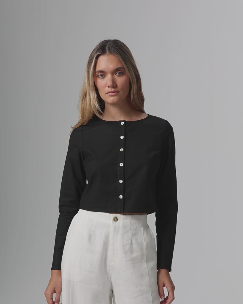 360-degree video of model wearing Aella Long Sleeve Woven Top (black), showing fit and movement.