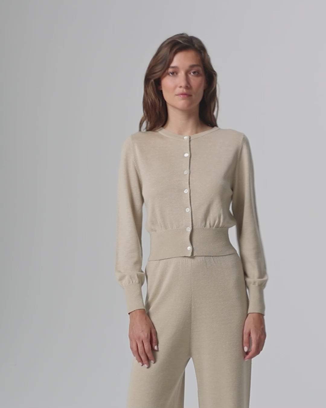 360-degree video of model wearing the Liora Knitted Hemp Cardigan (beige), showing fit, drape, and movement.
