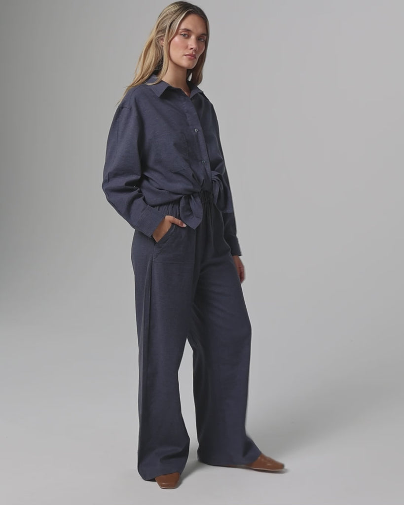 360-degree video of model wearing the Lyricist Oversized Shirt and Lyricist High Rise Pull-on Pants in indigo blue, showing fluid drape and movement.