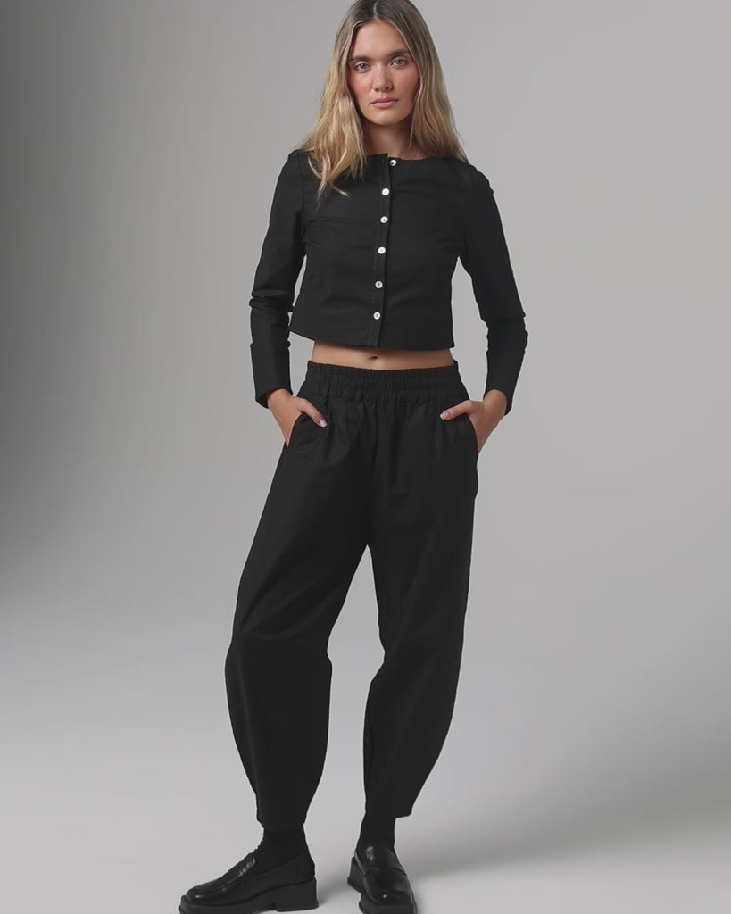 360-degree video of model wearing Aella Long Sleeve and Mid Rise Relaxed Tapered Pants (black), showing taper and movement.